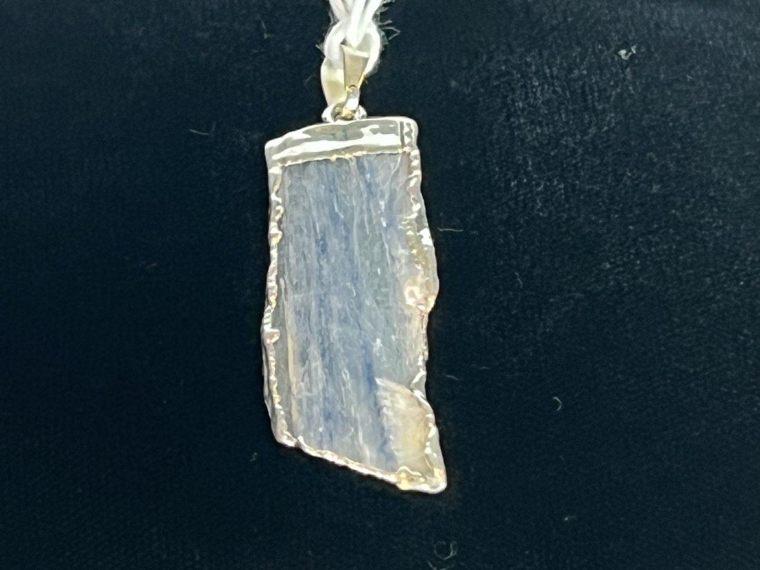 Blue Kyanite Pendant: Blue kyanite pendant with silver-colored plating on edges.