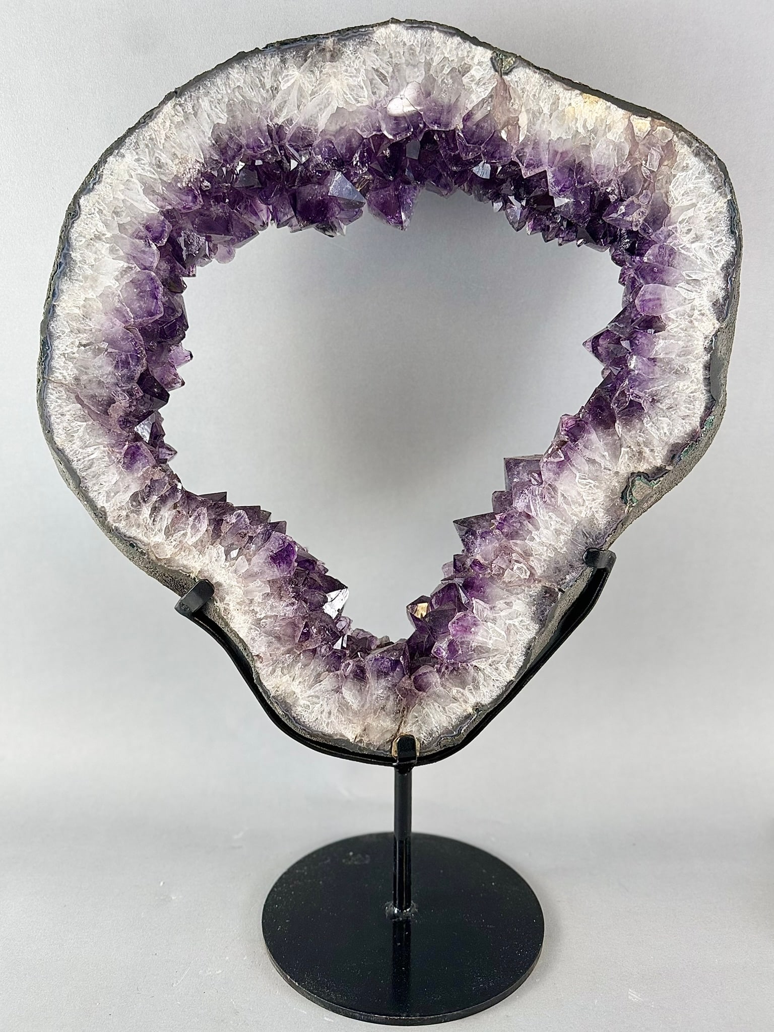Large Amethyst Geode Ring on Metal Stand: Large amethyst geode ring on custom metal stand from Brazil. 23” x 17” x 8”. 28 pounds, 4 ounces.