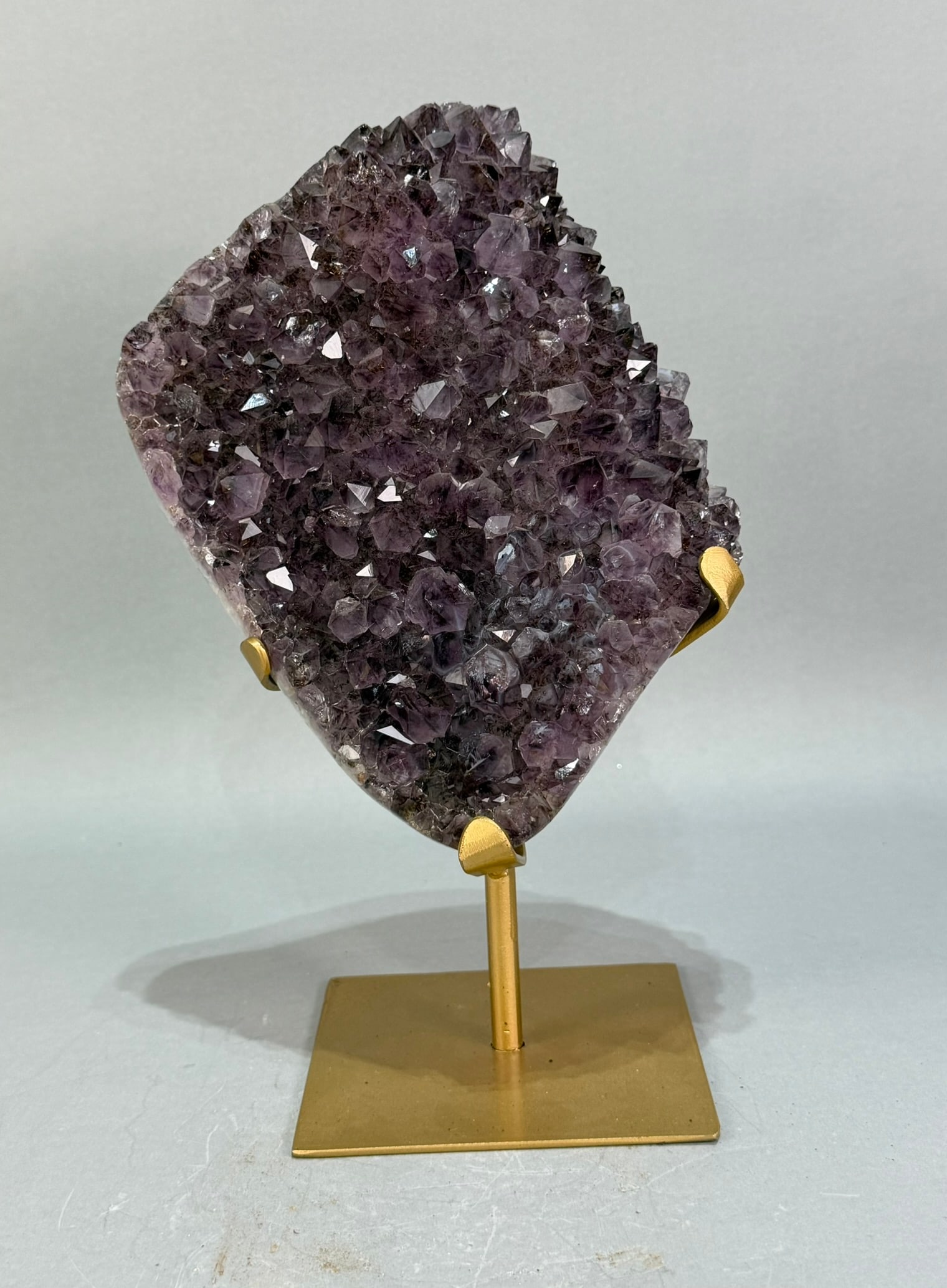 Amethyst Cluster on Metal Stand: Amethyst cluster on metal stand from Brazil. 11” x 7.5” x 4.5”. 6 pounds, 2 ounces.