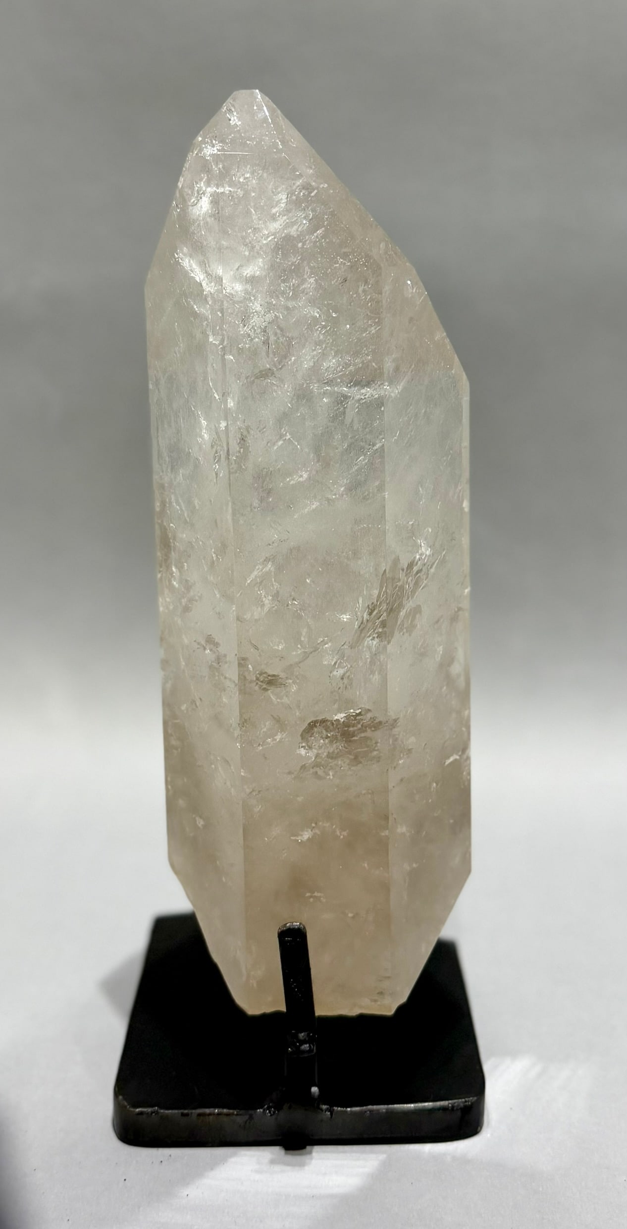 Clear Quartz Crystal With Inclusions on Stand: Clear quartz crystal with refractive inclusions on metal stand from Brazil. 13” x 5” x 5”. 9 lbs, 9 oz.