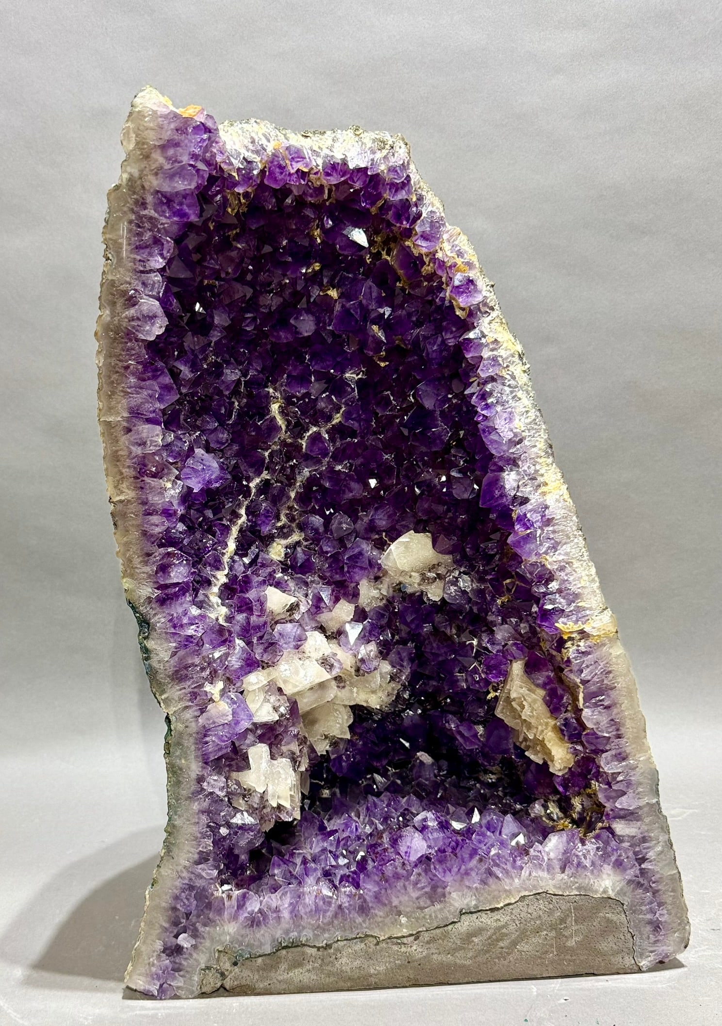 Large Amethyst Cathedral Geode: Large amethyst geode with fluorescent calcite crystals from Brazil. 19.5” x 13” x 10”. 45.5 lbs.