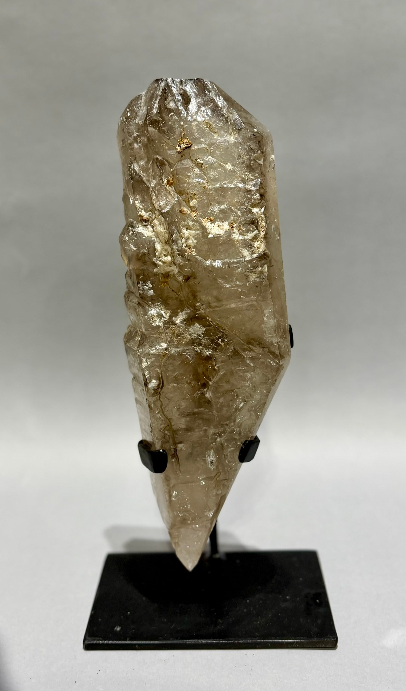 Smoky Quartz Crystal With Inclusions on Stand: Smoky quartz crystal with inclusions on metal stand from Brazil. 13.5” x 6.25” x 4”. 6 lbs, 4 oz.