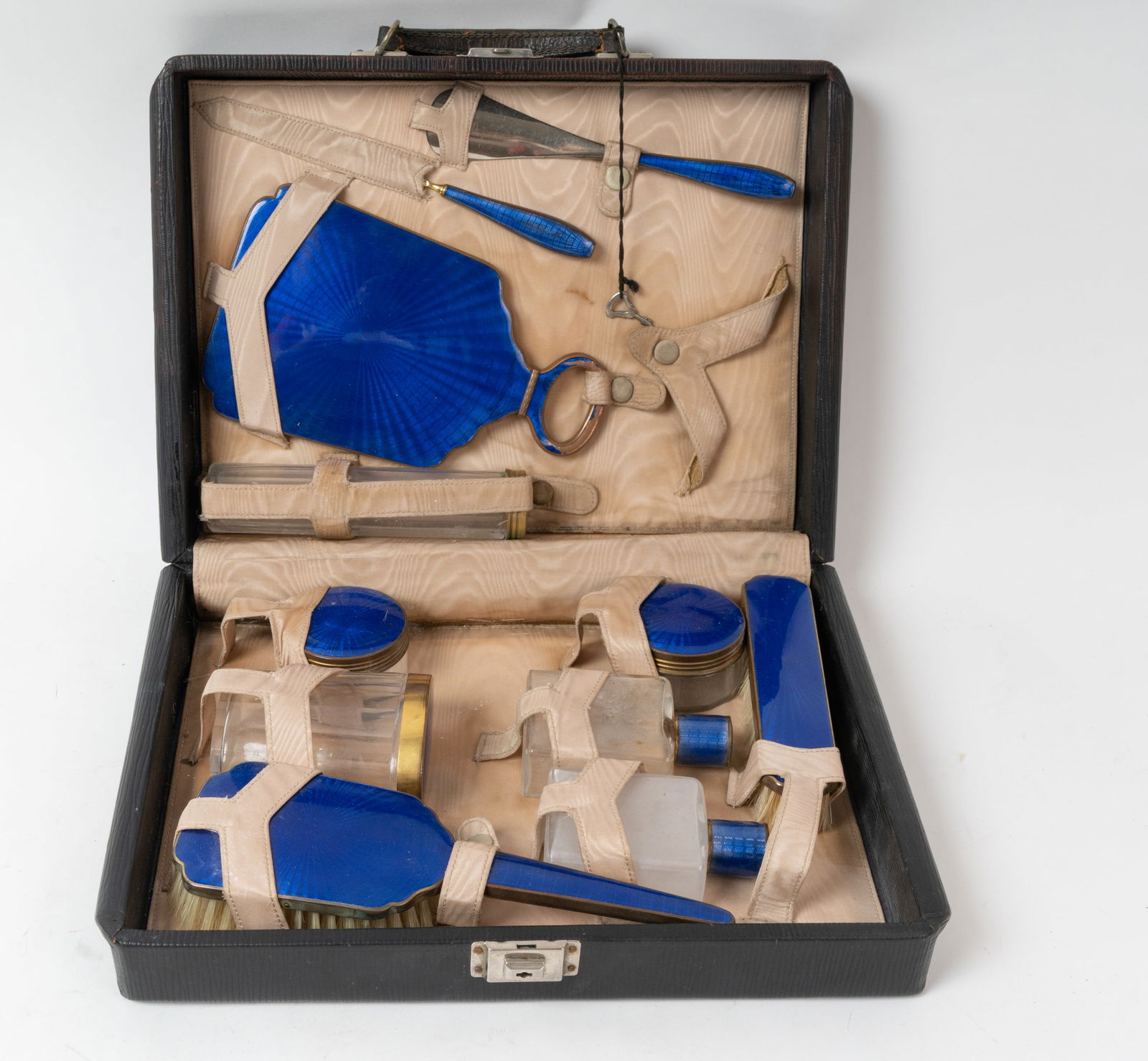Hard Cased Enameled 1930s Cosmetic Set.: A brilliant bright Blue design with brass covers on bottles. A glamorous item. Only the comb is missing. Shoe horn is stamped "M. Laysiefen Germany" There are wear spots to the enamel and plating but