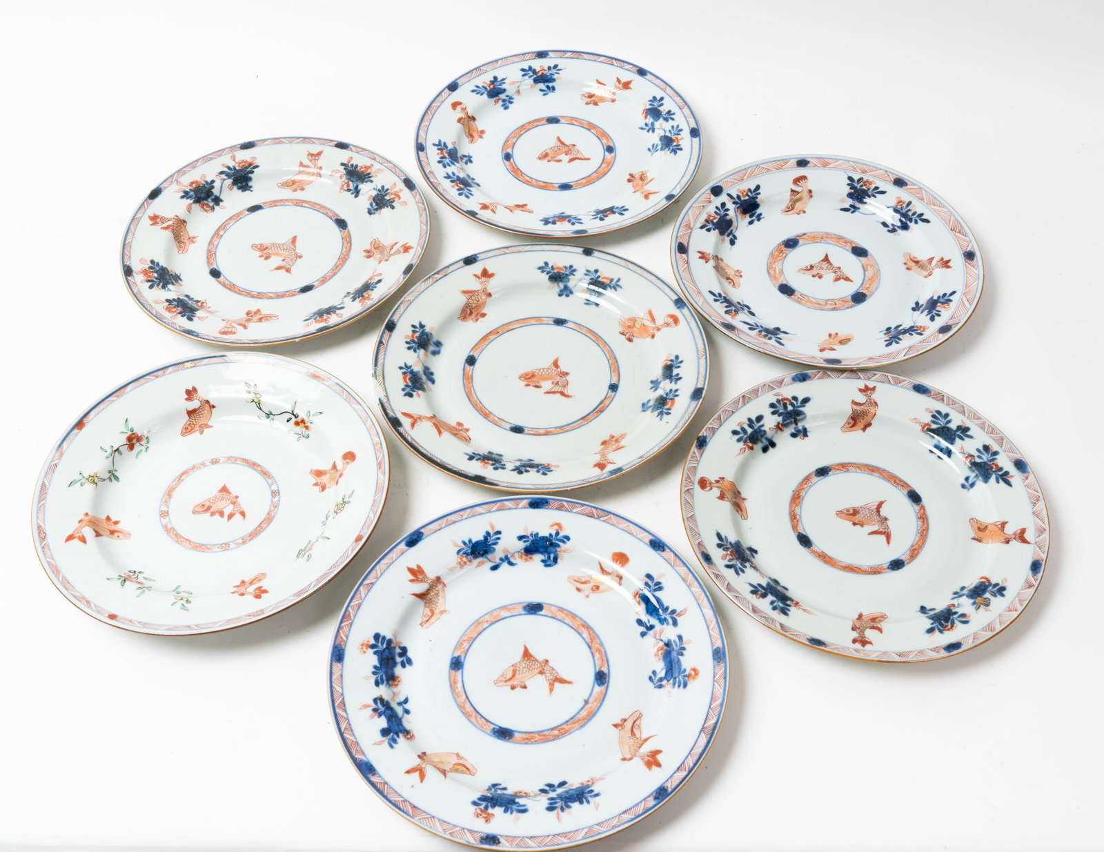 Lot of Seven 18th-C Chinese Export Porcelain Plates.: All of these plates have a Fish and Flower design that was hand painted. One plate has a 3/4" long glazing chip to the edge. Several minor knicks on other plate edges. They measure 8-3/4" in diameter.