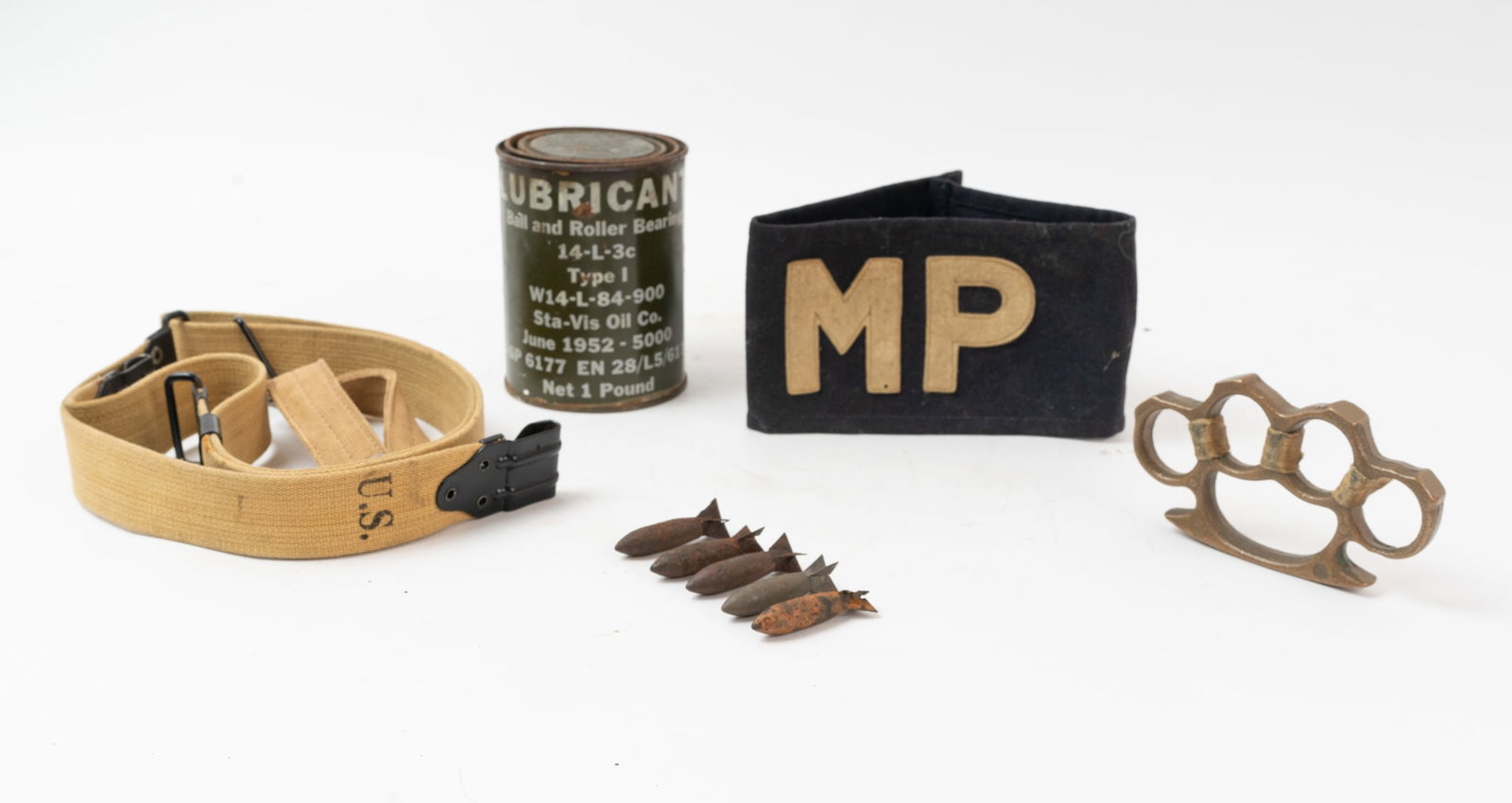 Lot of Five Military Items.: WWII era Grease can, M.P. Military Armband, Rifle sling, Mini bombs "Lazy Dog" clearing droplets, soldier Brass knuckles, and a Rock Island Marked canteen strap.