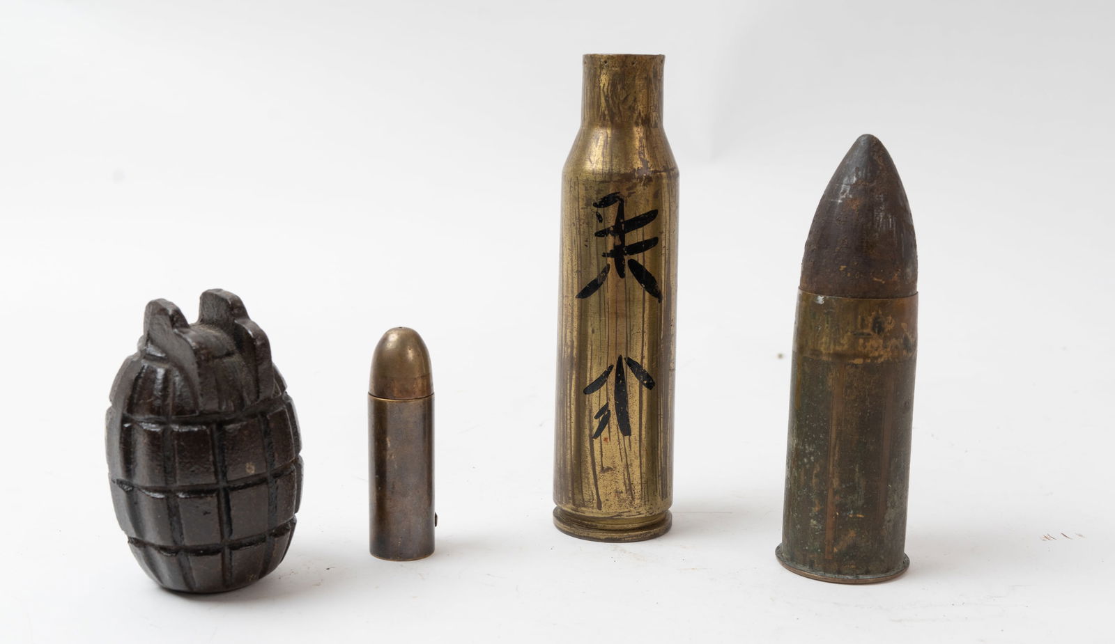 Lot of WWI & WWII Trench Art, Lighter, Shells.: Neat military grouping. A German WWI Tank Division Lighter, An inert practice only U.S. Pineapple grenade, a Model 1916 37mm complete spent round, and a 37mm shell with Japanese characters and a small