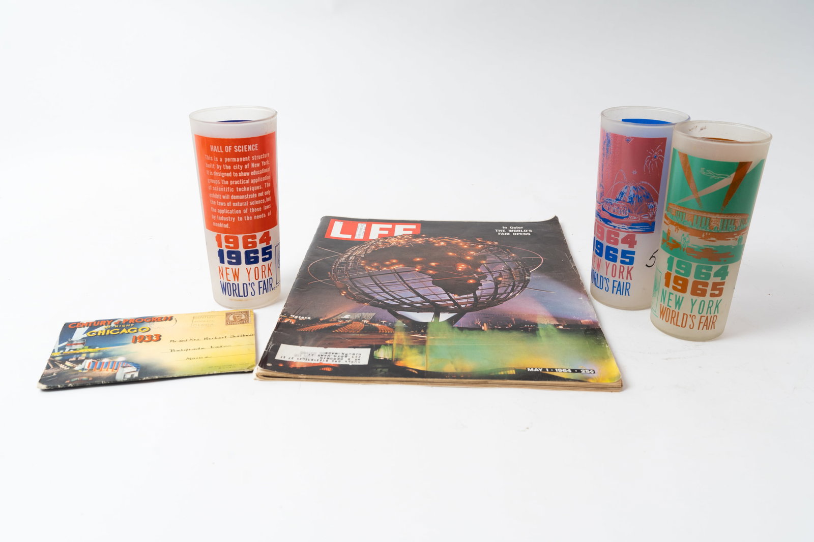 Lot of Five Worlds Fair Items.: Three original 1964-65 New York Worlds fair frosted glasses. They measure 6-1/2" x 2-3/4". A 1933 Chicago Century of Progress folder with prints of attractions. Measures 4" x 6". And a May of 1964 Lif