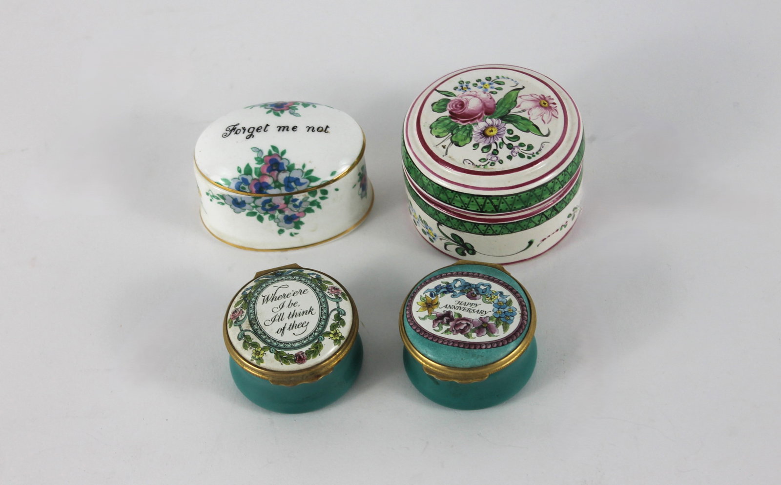 4PC Halcyon Staffordshire & French Pill Boxes: Includes a Halcyon enameled "Happy Anniversary" box, a Halcyon "Where'ere I be I'll Think of Thee" box, a Staffordshire "Forget Me Not" porcelain box, and a French botanical box.