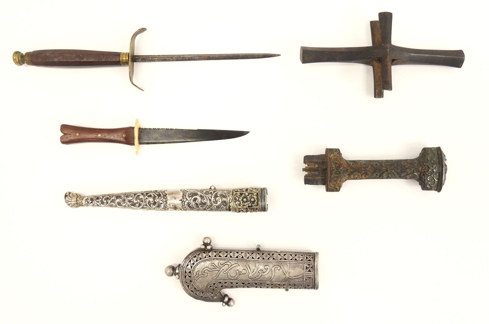 Group of Middle Eastern Sword Parts and Daggers: A small dagger with a wooden grip, bone guard, and a blued blade (7 1/4"); a small dagger with a wooden grip, brass fittings, and a triangular blade (10 1/4"); a hilt of an early dagger with missing b