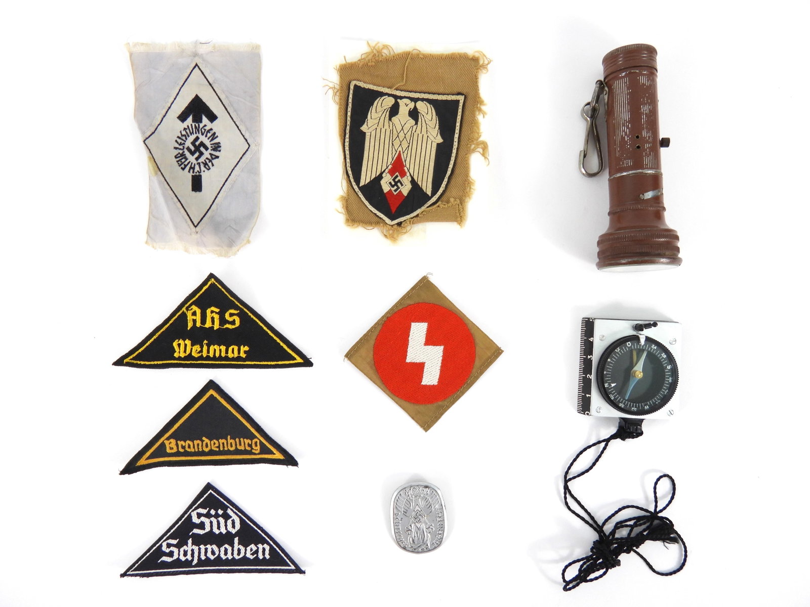 Group of WWII Hitler Youth Items: A brown-painted flashlight and belt clip marked "Pick" on the screw-off cap; a compass marked on the back "marsch-/Kompass/Jugend" and "D.R.G.M"; six sleeve insignia; and a tinnie.