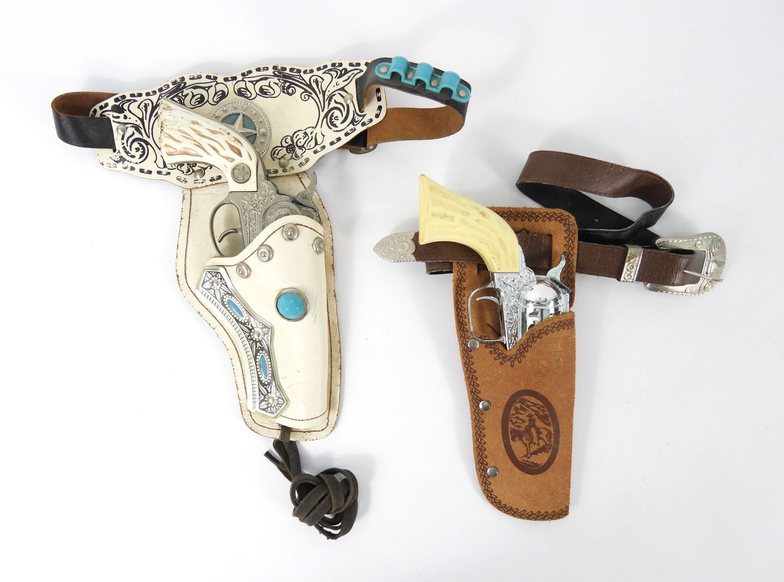 2PC Hubley Texan Jr & Pony Boy Cap Guns: Includes a Texan Jr. cap gun with a white leather holster, and a Pony Boy cap gun with tan leather holster. From the collection of a Northboro, Massachusetts estate.