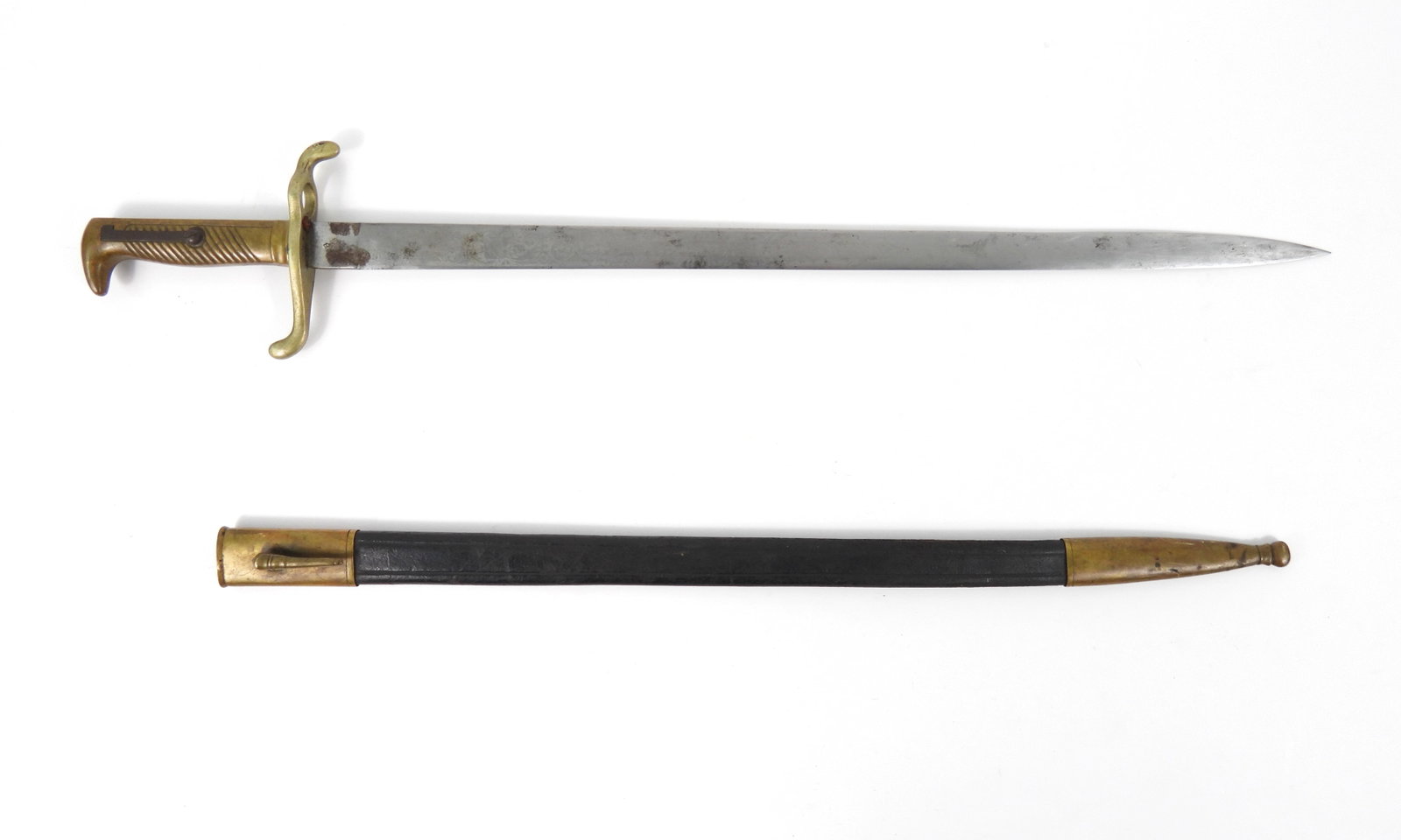 German Model 1871 Training/Parade Bayonet: Brass hilt (not cut for mounting on a rifle), brass hilt, steel blade engraved with foliate designs, a knapsack, and a Pickelhaube, and a leather scabbard with brass fittings. Blade lg. 19", Overall l