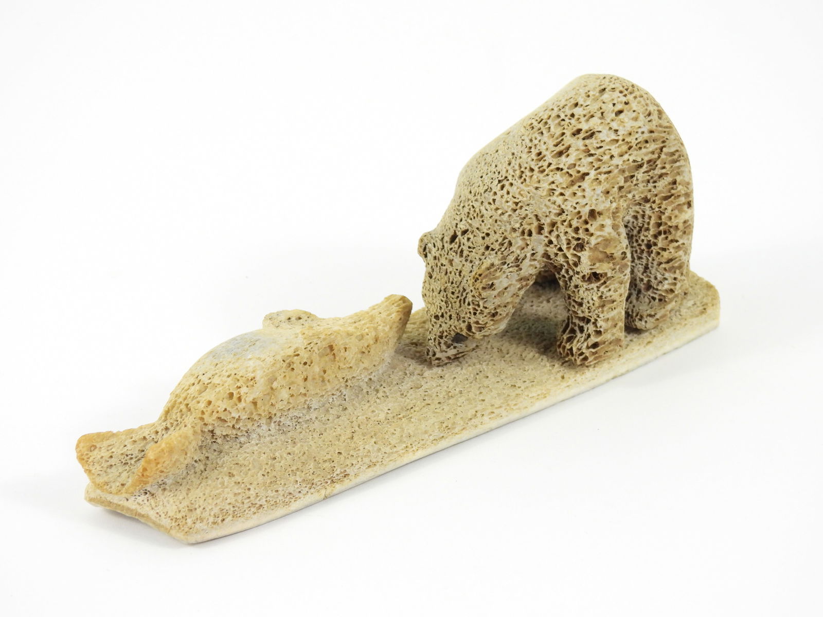 Inuit Carved Petrified Bone Polar Bear Sculpture: North America, 20th Century, Bone. Carved bone depiction of a polar bear preying on a seal. From the collection of a Princeton, Massachusetts estate.