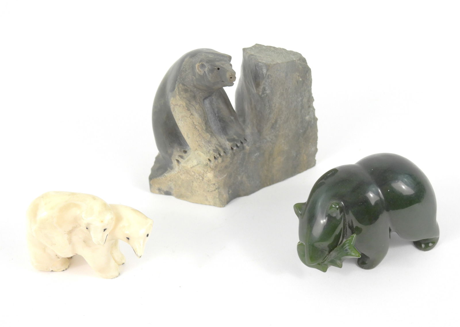 3PC Inuit Carved Stone & Bone Bear Sculptures: North America, 20th Century, Stone, bone. Includes a green stone carved bear holding a fish in their mouth, a carved bone pair of polar bears, and a gray stone bear on a rock by Roy Klengenberg, also