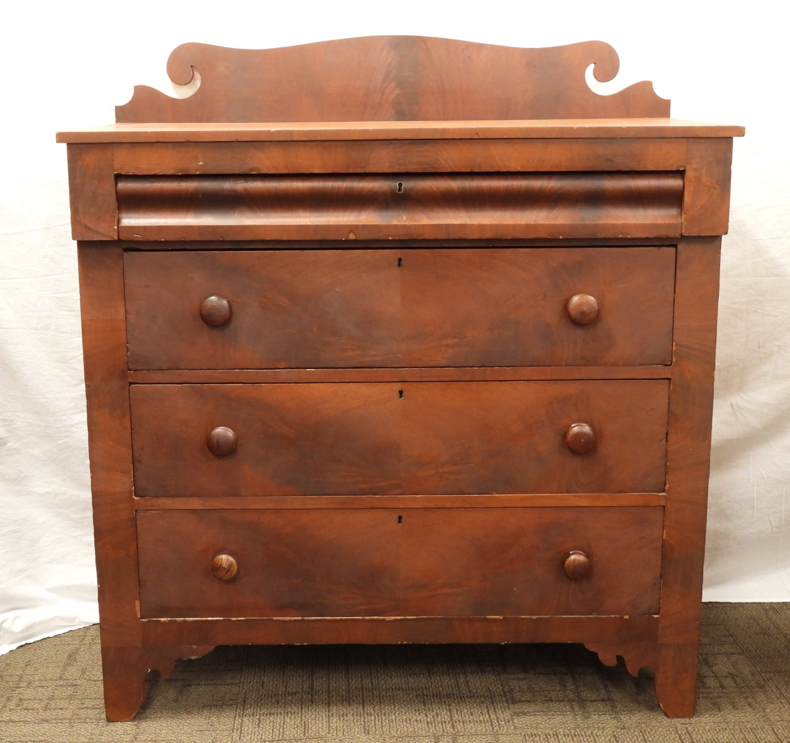 Antique Empire Dresser: United States, 19th Century, Wood. A four drawer dry wash finish with figured wood drawer fronts. Top drawer has hidden underside handle scoops. From the collection of a Sutton, Massachusetts estate.