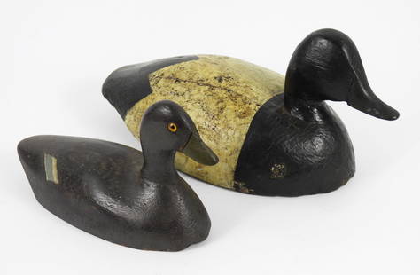 2PC Carved Wood Decoy Ducks: 20th Century, Wood. Includes small dark gray duck with yellow glass eyes, and a large black and white duck. Smallest 5 3/4" t x 4" w x 9 1/2" d, Largest 6 1/2" t x 6" w x 15" d