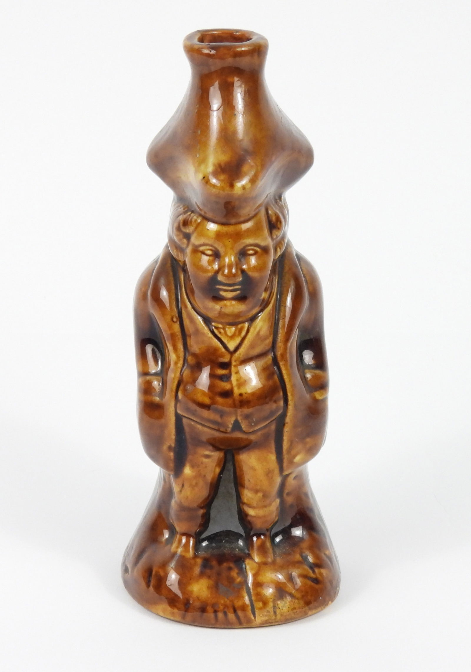 Attr. Bennington Rockingham Toby Flask Bottle: United States, Late 19th Century, Pottery. Brown glaze pottery flask depicting a gentleman in a waistcoat with a large hat. Approx. 7 3/4" x 3 1/4" dia.