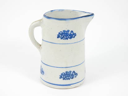 American Blue & White Stoneware Pitcher: United States, Late 19th-Early 20th Century, Pottery. Handled pitcher with three thin blue bands and botanical decoration. Approx. 8 3/4" x 8" dia.