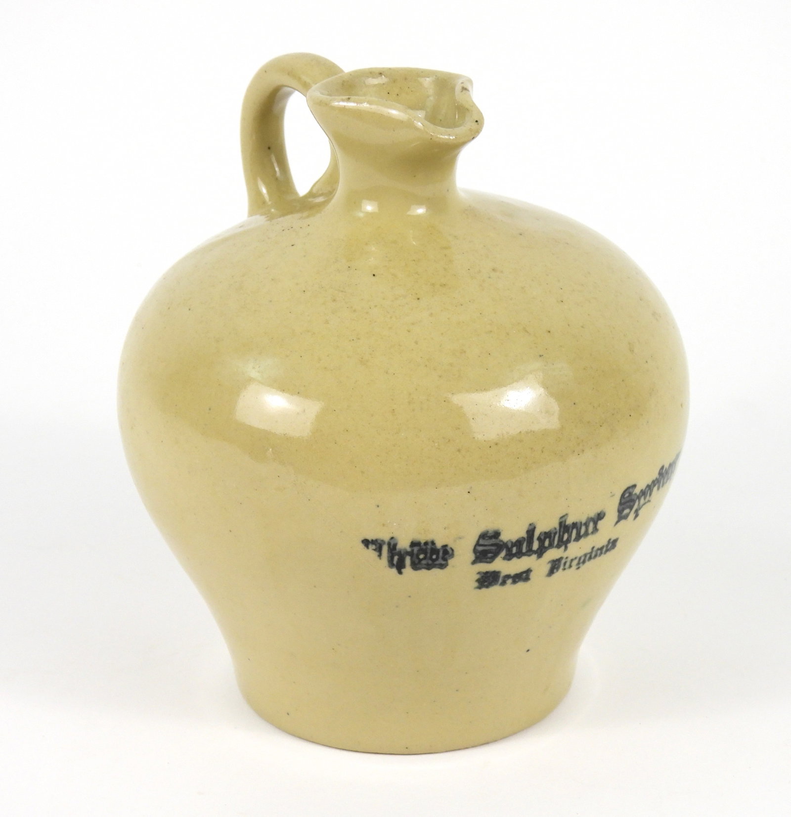 White Sulphur Springs Ceramic Advertising Pitcher: United States, Early 20th Century, Ceramic. Squat cream colored pitcher with cobalt blue stamp marked "White Sulphur Springs West Virginia" to front. Approx. 7" x 6" dia.