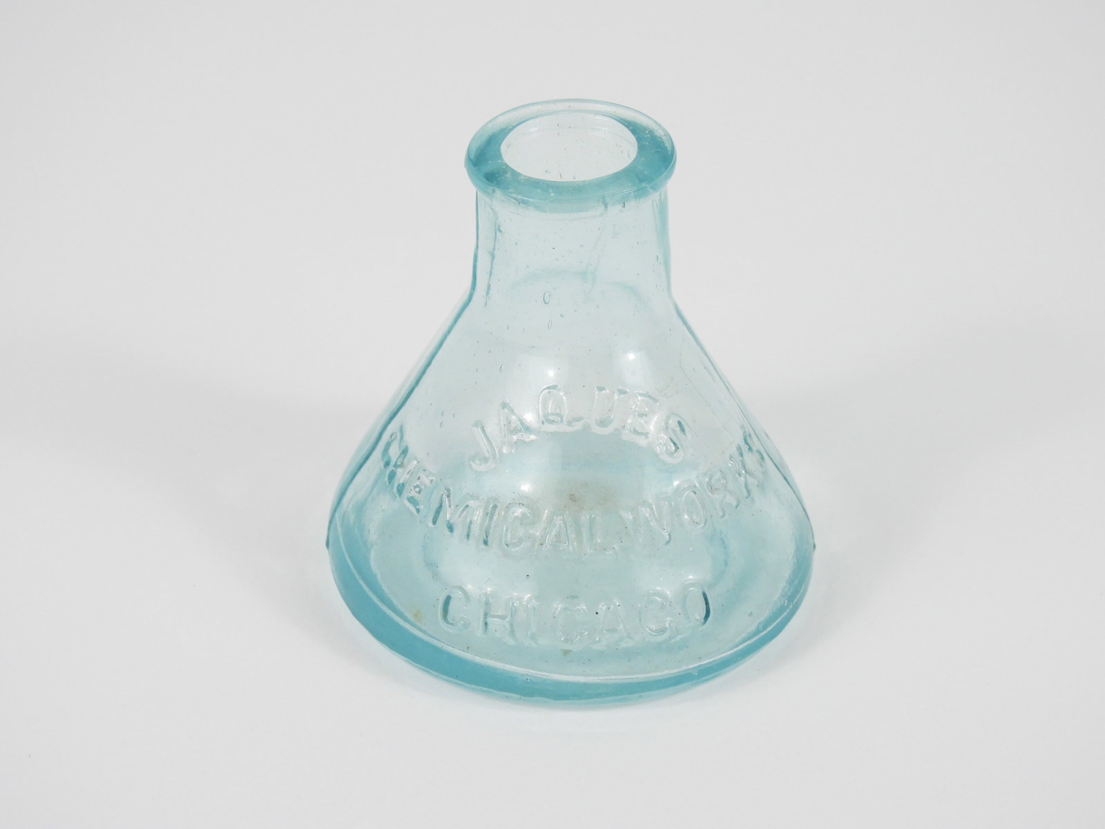 Early Jaques Inkwell Bottle: United States, 19th Century, Glass. Good condition without any observed damage, aqua color two mold ink marked "JAQUES CHEMICAL WORKS CHICAGO." Approx. 2 5/8" x 2 1/2"