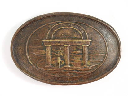 Georgia State Seal Belt Plate: United States. Lead-filled brass plate with the Georgia state seal on the face and two brass puppy paw attachment tabs on the back alongside a brass tongue. Overall 2 1/8" x 3 5/16"