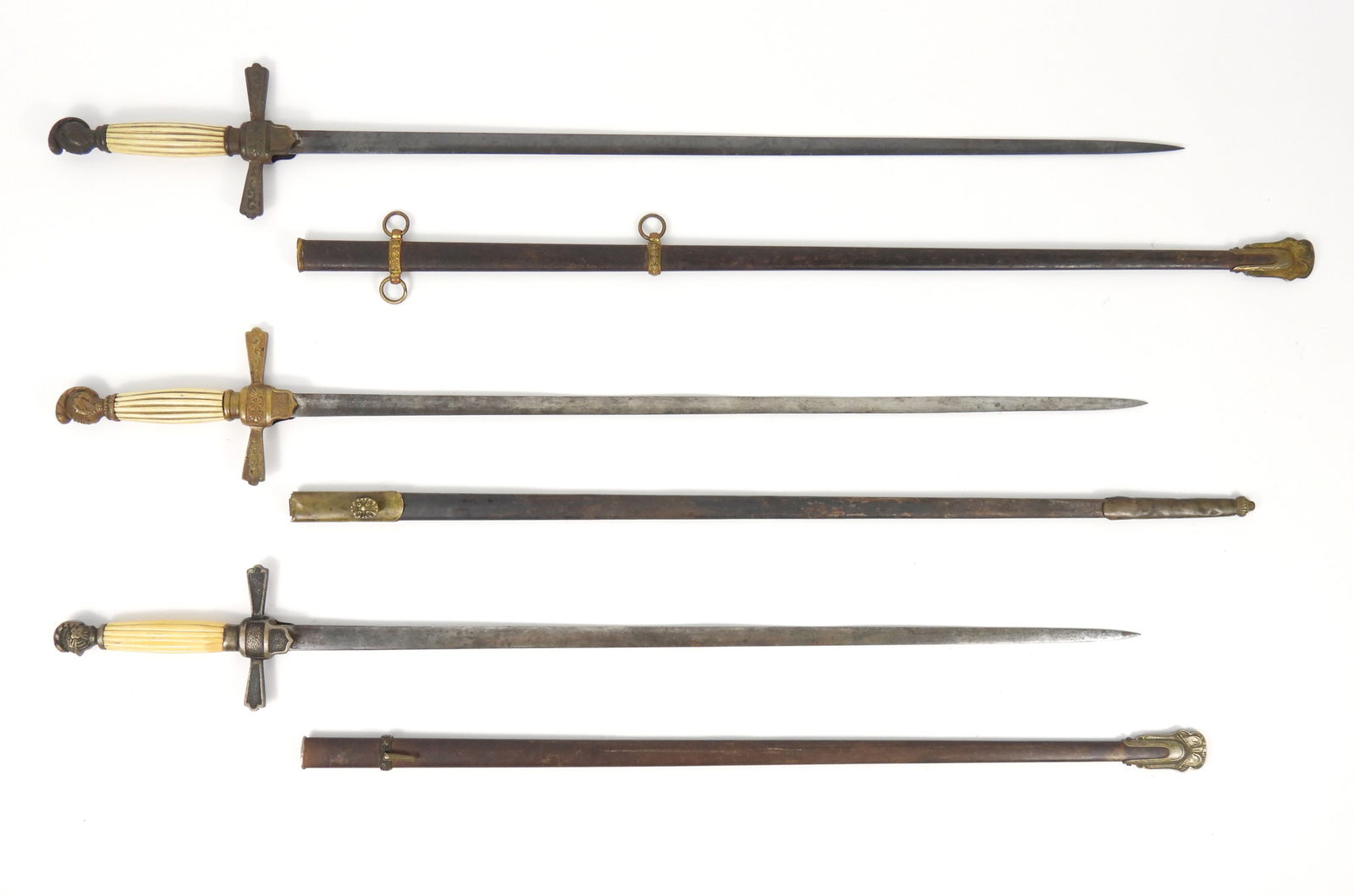 Three Militia NCO Swords and Scabbards: United States, Mid 19th Century. Three militia NCO swords with knight's head pommels, reeded bone grips, and brass guards with steel blades and scabbards.