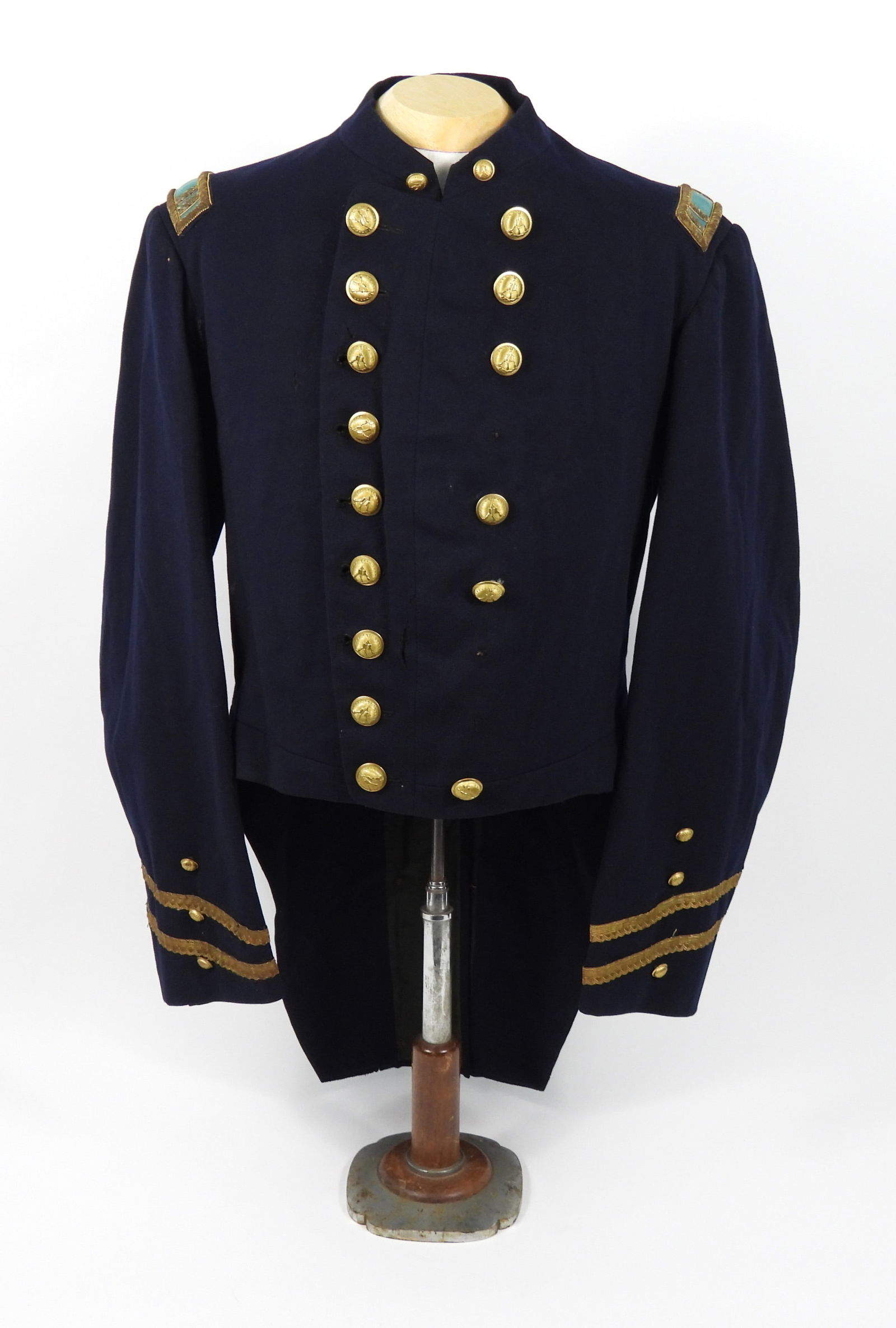 Poughkeepsie Military Institute Coatee: United States. Dark blue broadcloth body with gold metallic tape on the cuffs, captains shoulder straps; "P.M.I." buttons with Schuyler, Hartley, and Graham back marks, and a green silk lining.