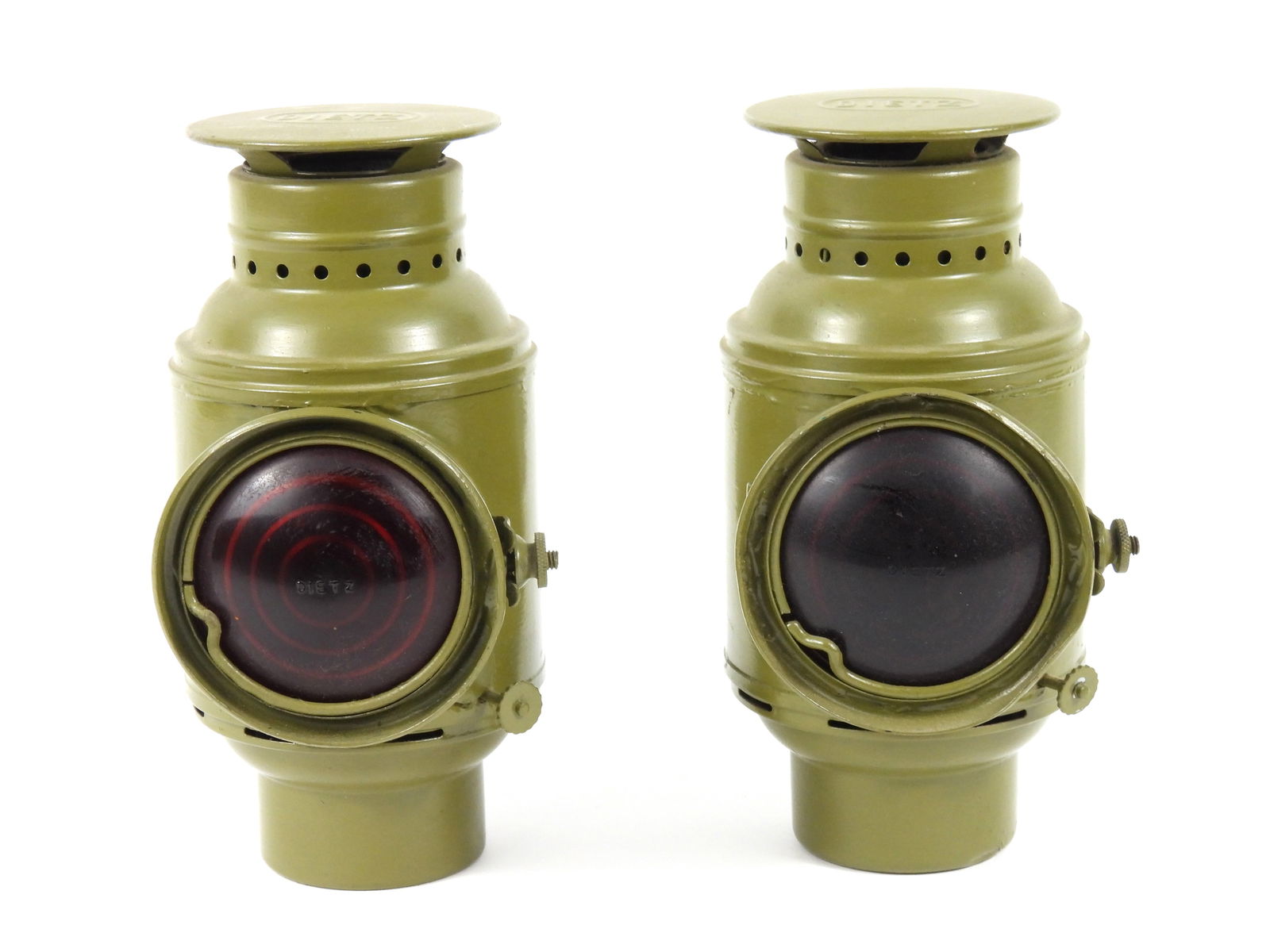 PR WWI-Era Dietz Vehicle Lanterns: United States, Early 20th Century. Kerosene style military Army truck lamps with red glass lenses in each. They appear to heave never been used with original wicks and tinned interiors. Exterior of ea