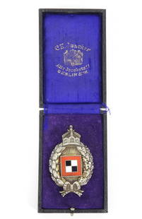 WWI German Cased Prussian Aviation Observer Badge: Germany. Black case, purple silk liner marked "C.E. Juncker" with Berlin address, and a silver-washed badge with a crown, wreath bow, and and enameled red, black, and white squares. Overall 2 3/4" x 1