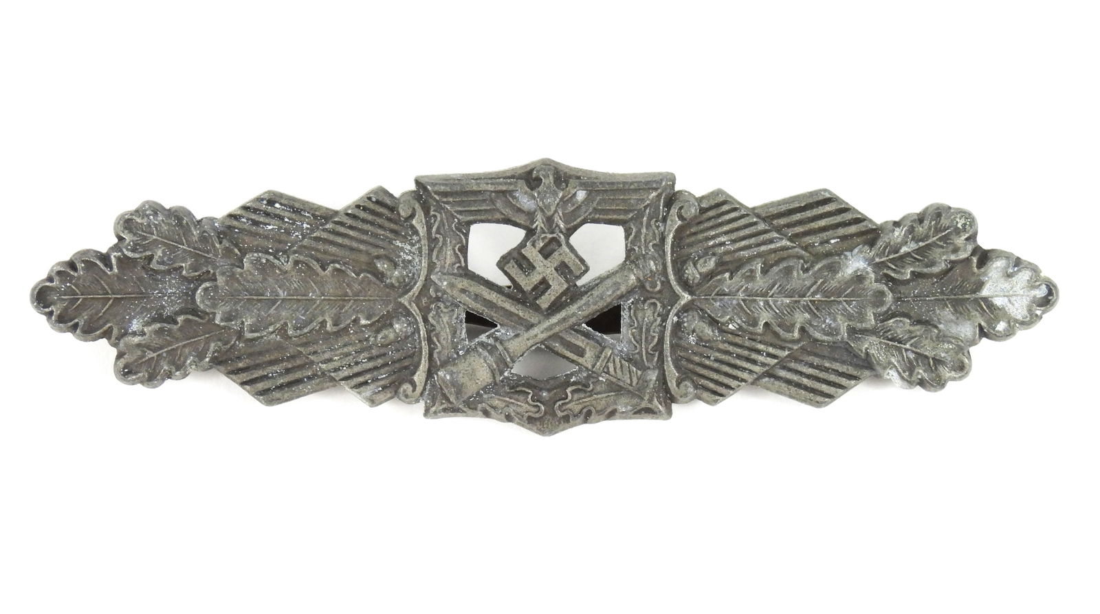 WWII German Close Combat Medal: Germany. A zinc badge with foliate designs, oak leaves, a crossed grenade, bayonet, and eagle and swastika, marked on the back "FEC.W.E.PEEKHAUS/BERLIN" with three circles with "F/L/L" in the middle,