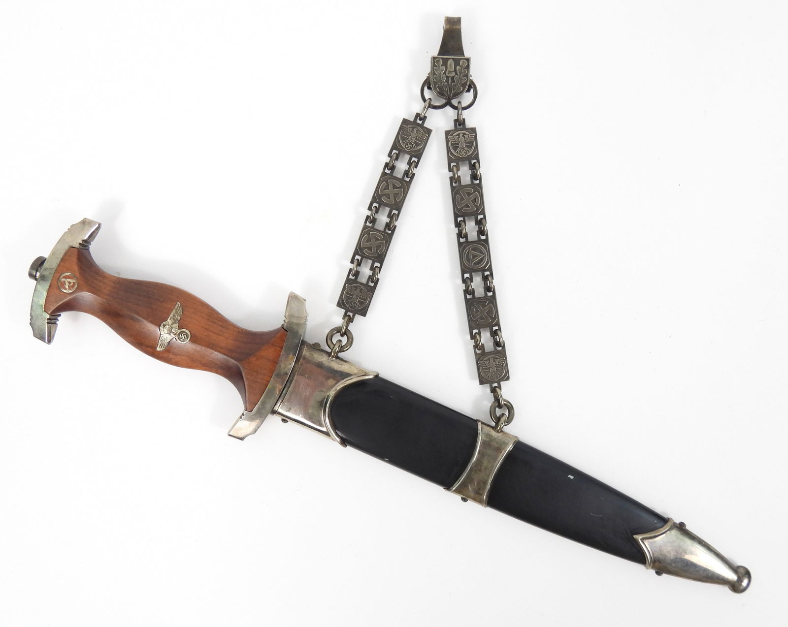 WWII German NSKK Chained Officers Dagger: Germany, Circa 1939. Nickel-plated guards, rosewood grip with "SA" roundel and eagle with wreath and swastika, the lower guard is numbered "227053", steel blade marked "Alles fur Deutschland" on one s
