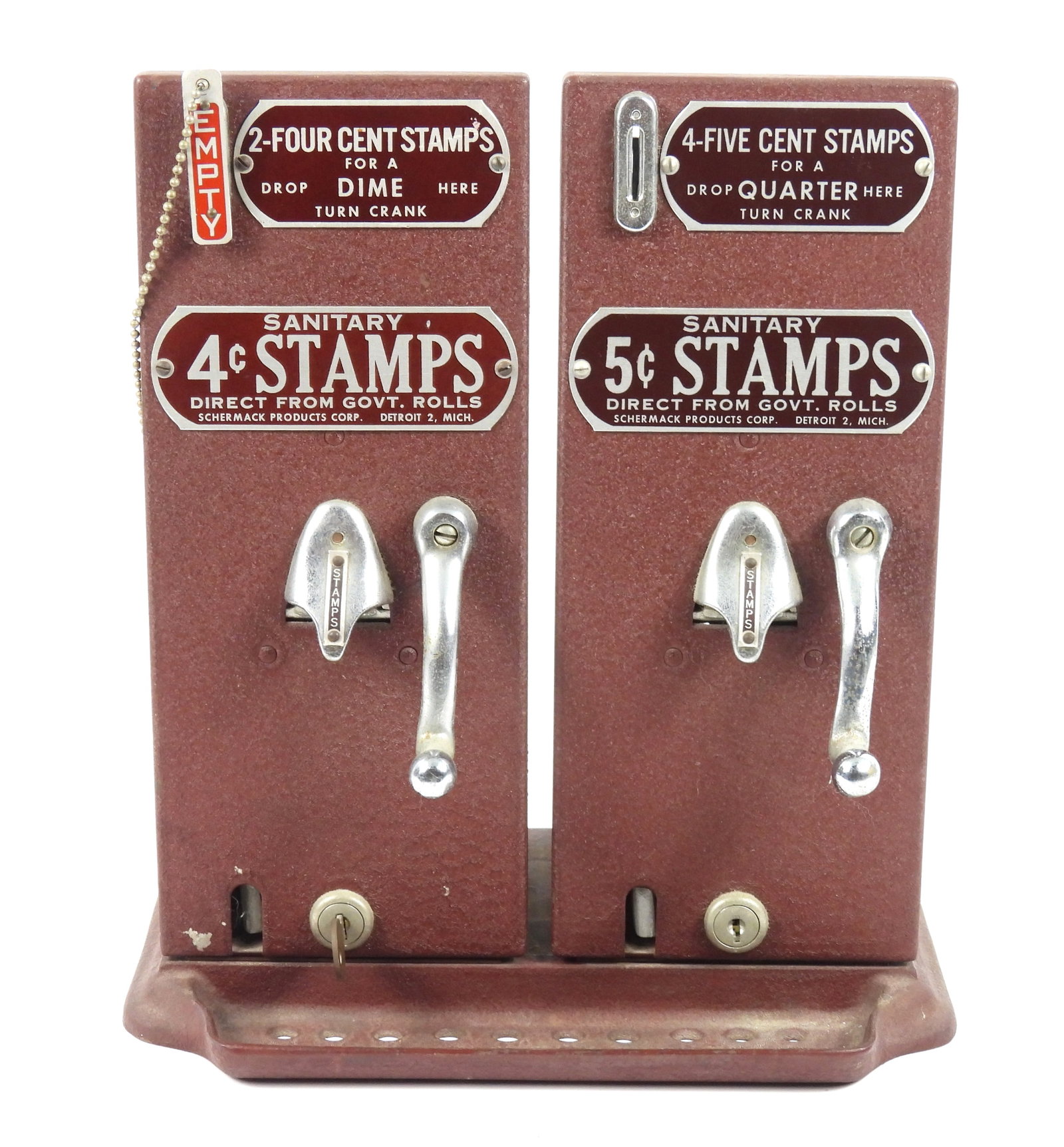 Schermack Two Slot Sanitary Stamp Dispenser: United States, Mid 20th Century, Metal, plastic. Two slot cranberry colored Schermack stamp dispensers advertising 4 and 5 cent sanitary stamps.