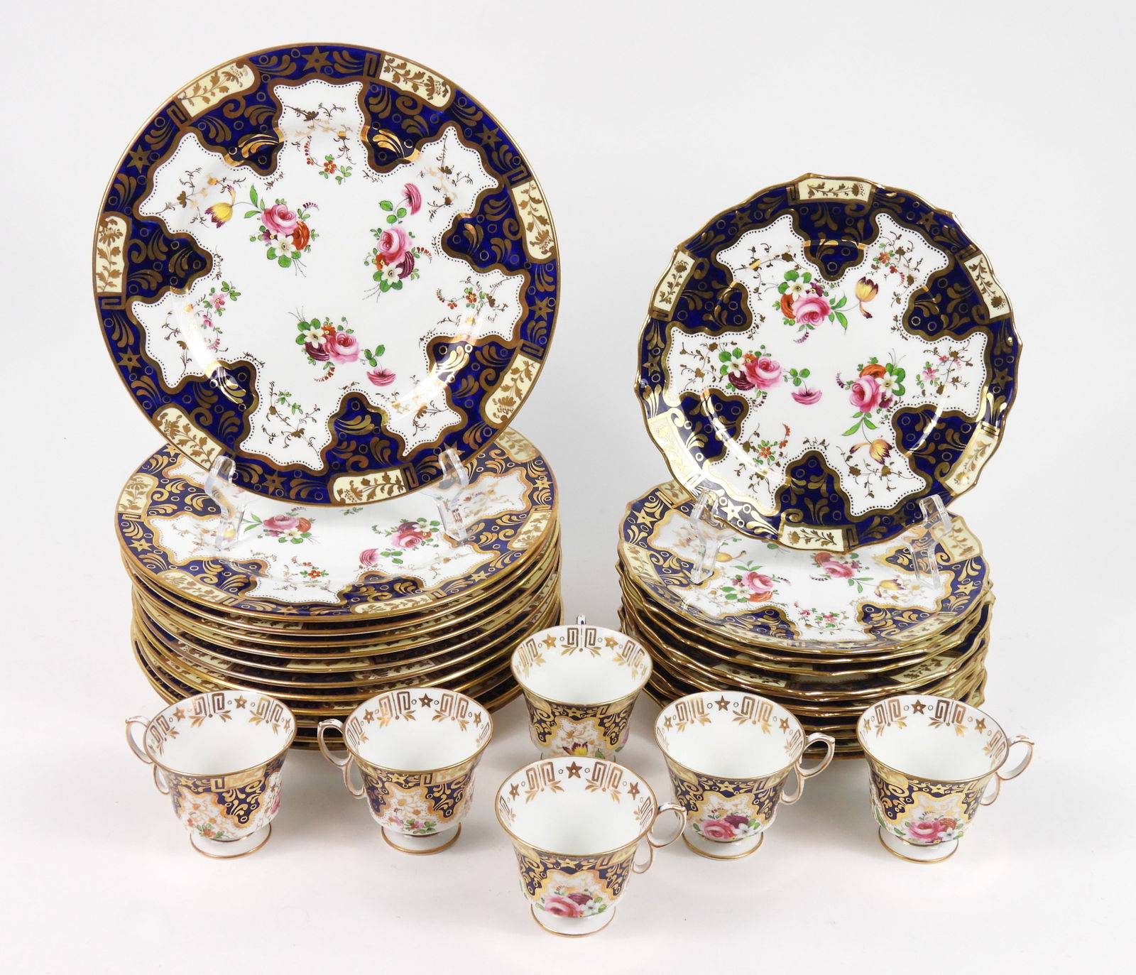 40PC Crown Staffordshire Porcelain Dinnerware: England, Circa 1930, Porcelain. Includes twelve dinner plates, four liners, six saucers, six teacups, and twelve luncheon plates decorated with polychromatic and gilt flowers surrounded by a cobalt bl