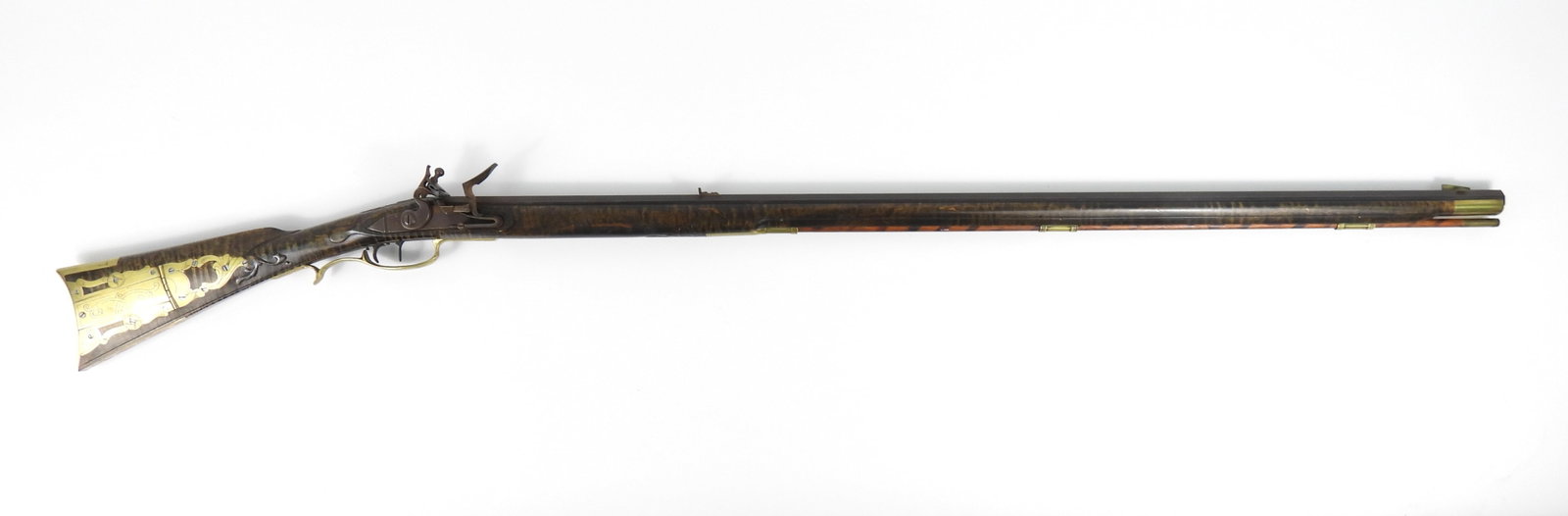 Reproduction Full Stock Kentucky-style Rifle: United States. .50-caliber bore, NSN, maple stock with raised carvings, brass patch box and fittings, stepped tail lock, set triggers, a hex head vent liner, an unmarked octagonal barrel, front and re
