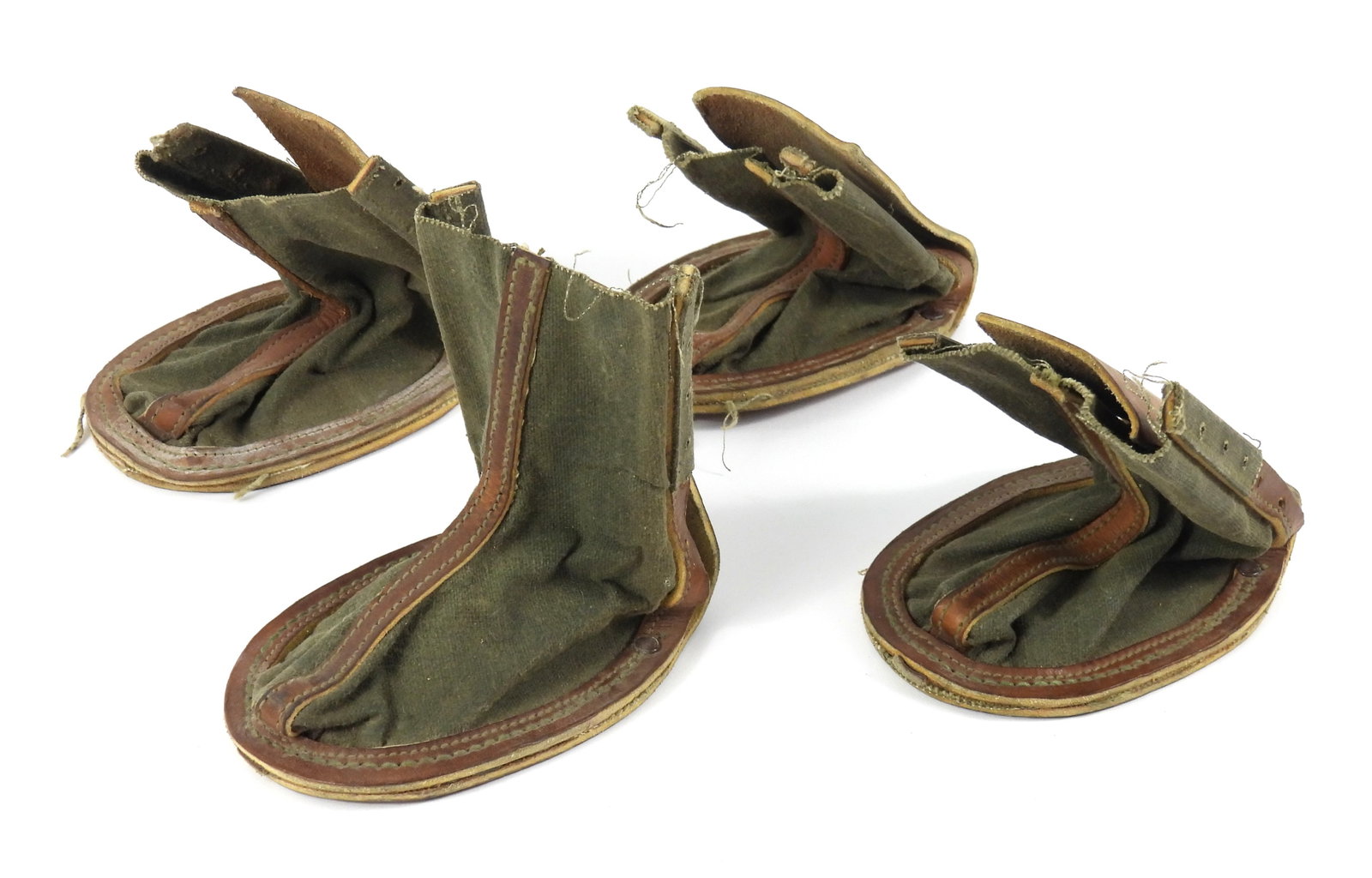 WWII War Dog Boots/Bootees: United States. Four war dog boots with one piece leather soles/back marked "RAY ALLEN MFG. CO./COLO SPGS, COLO", with canvas upper and leather lace eyelet holes, each with the tie/laces inside.