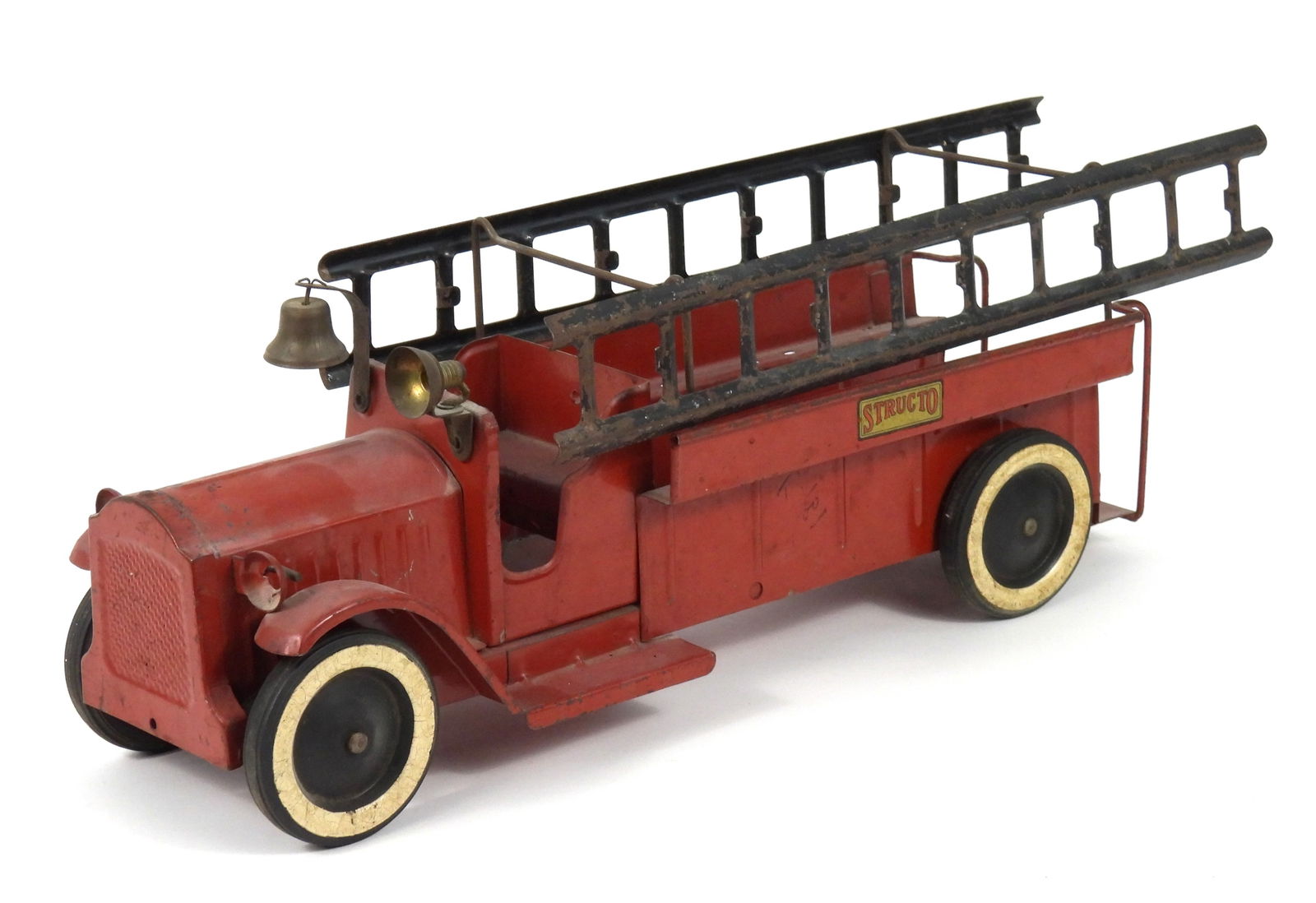 Antique Structo Pressed Steel Firetruck: United States, Early 20th Century, Pressed steel. Red pressed steel firetruck with bell, ladders, and rubber tires. Approx. 7 1/4" t x 18" w x 5 3/4" d