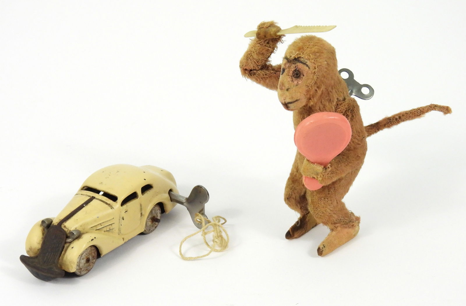 2PC Schuco & C.K. Post War Wind-Up Toys: Japan, Germany, Mid 20th Century, Metal, textile, plastic. Includes a C.K. wind-up Jolly Jacko holding a white comb and pink mirror; and a Schuco U.S. Zone Germany made model 1001 white wind-up car.