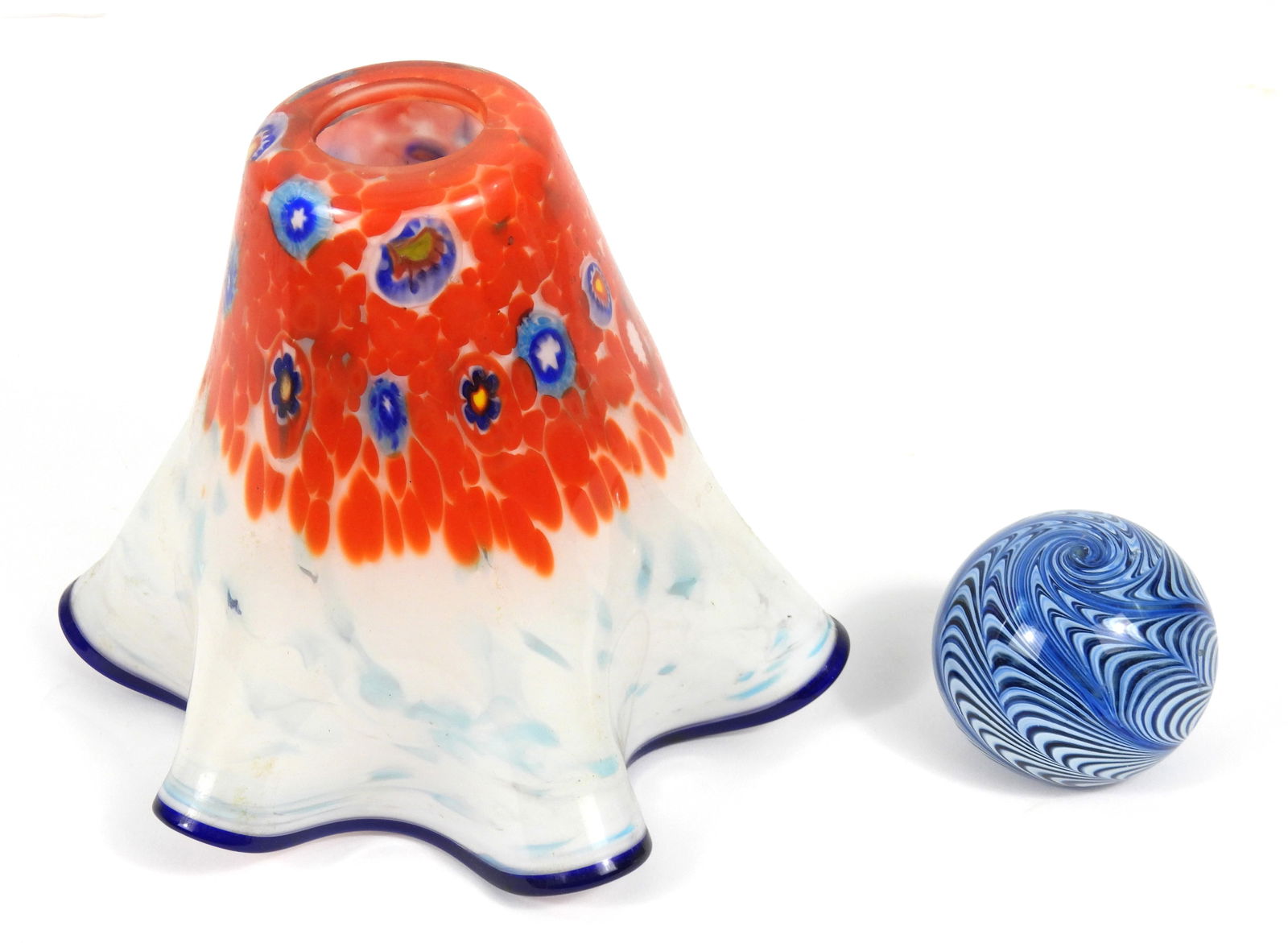 2PC Art Glass Lampshade & Paperweight: 20th Century, Glass. Includes a Murano style millefiori lampshade with ruffled rim, and a OBG blue and white feather pull paperweight. Smallest 2 1/2" x 2 3/4" dia., Largest 7" x 8 1/2" dia.