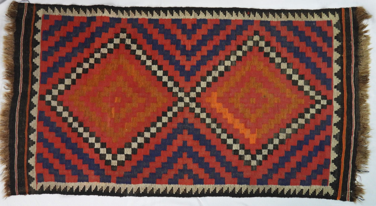 Semi Antique Turkish Kilim Type Rug: Brightly colored hand woven geometric stepped pattern diamonds with fringe ends. Approx. 39" x 76"