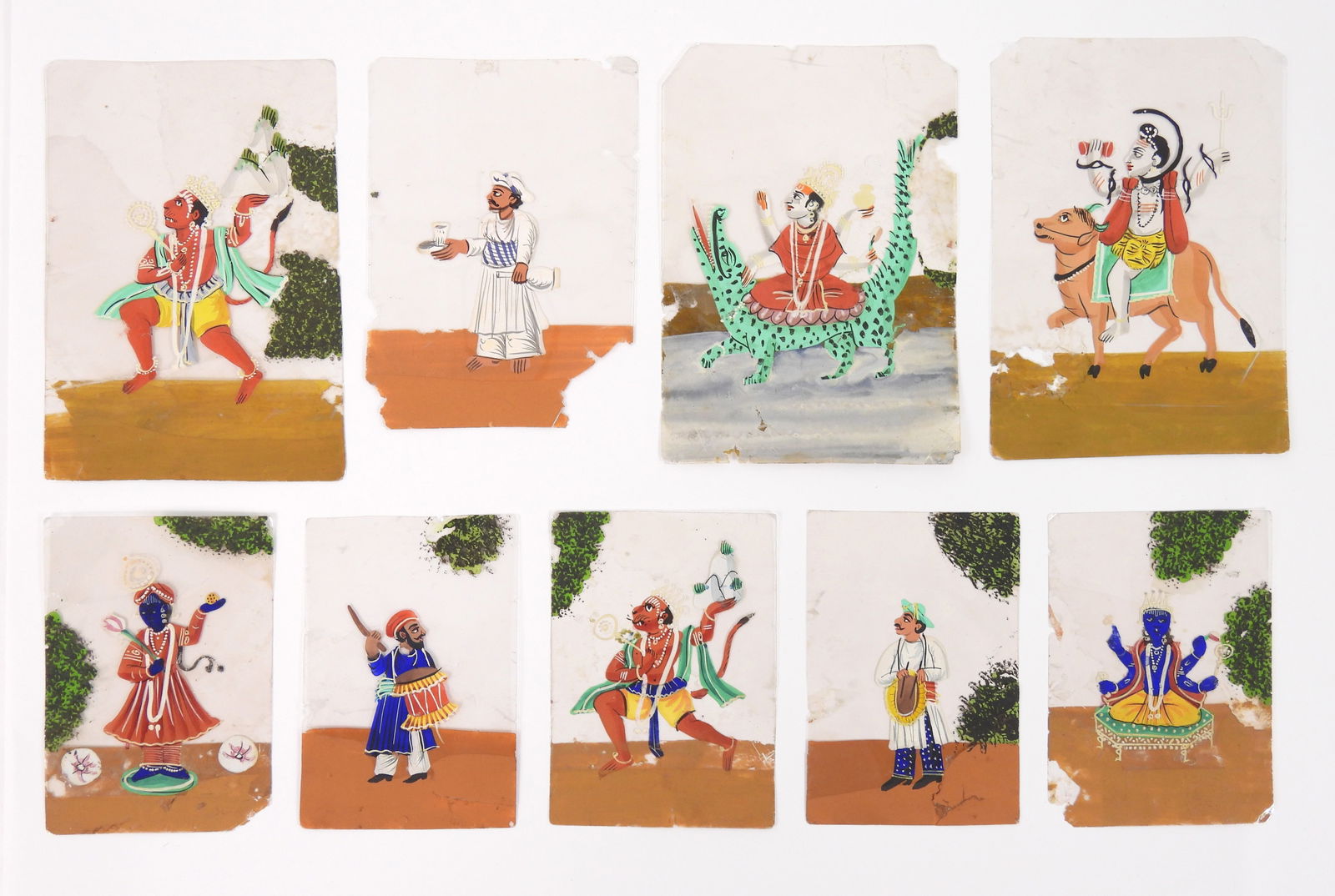 9PC Indian School Miniature Mica Paintings: India, Early 20th Century, Paint on mica, paper. Total of nine Indian mica paintings depicting various gods and figures including Varuna, Shiva, Krishna, and Hanuman carrying Dronagiri Mountain. 