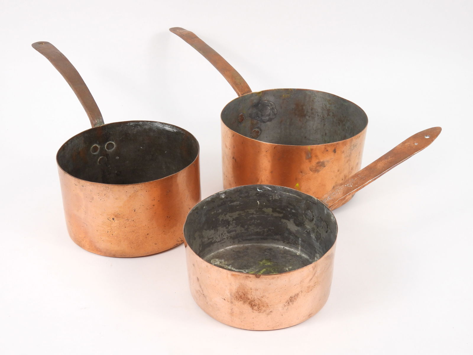 3PC Antique Graduated Copper Pans: Includes a large 4 1/2" x 8 1/4" dia pan, measuring 18 1/2" long with handle; a medium sized 4 1/2" x 7 1/2" dia. pan measuring 16 1/2" long with handle; and a small 3 1/2" x 7 1/4" dia. pan 