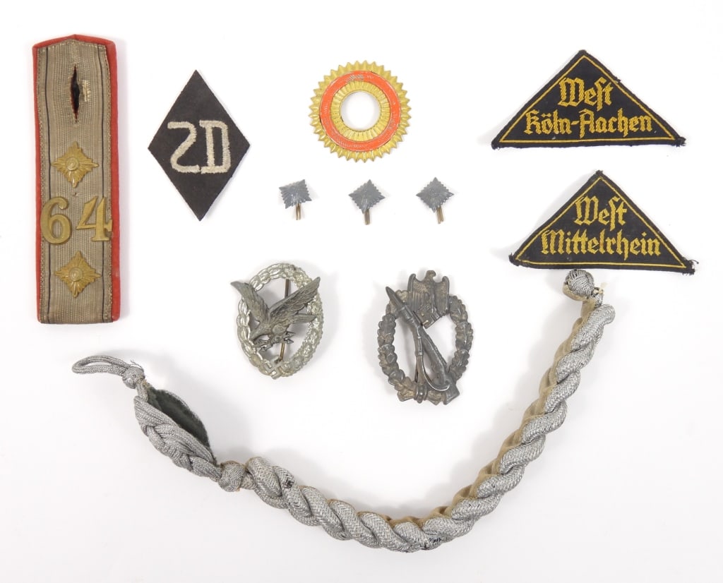 Group of WWI and WWII German Insignia: Two Hitler Youth insignia; an "SD" patch; a cockade for a picklehaube; three brass pips; an epaulet with metallic tape, pips, and "64"; an officer's silver shoulder cord; an Infantry Assault badge;
