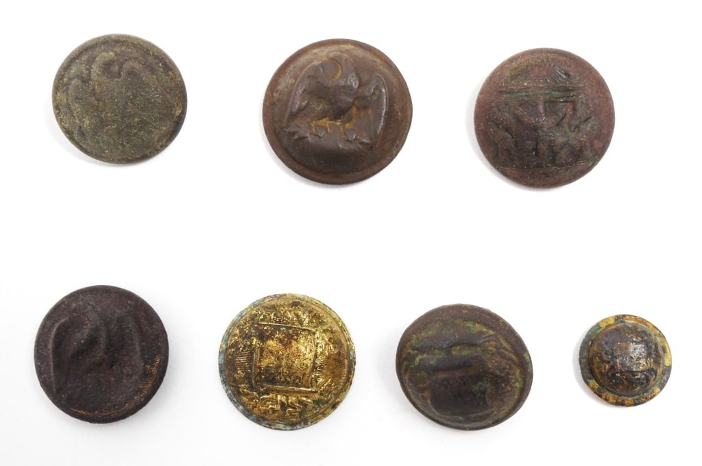 Group of Dug Confederate Buttons: A coat-size Georgia button with some wear and a dent in the face, bent shank, and "HORSTMANN & ALLIEN/NY" back mark (22.8mm); the front face of a three-piece coat-size Alabama button with some gilt wa