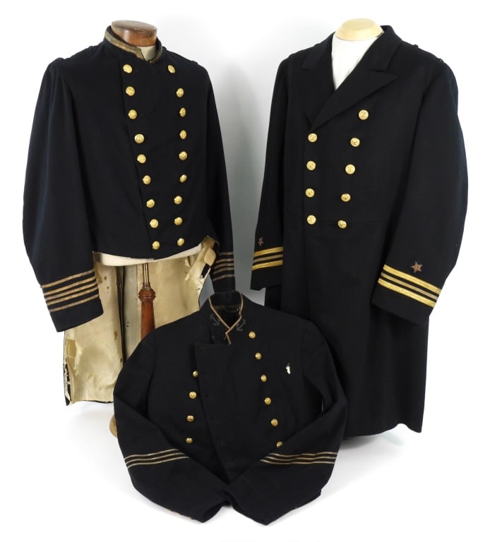 Three US Navy Coats: A dark blue broadcloth coatee with gold metallic tape on the cuffs and collar, brass buttons, and a silk liner which is worn and damaged; a dark blue/black navy frock coat with lieutenant commander