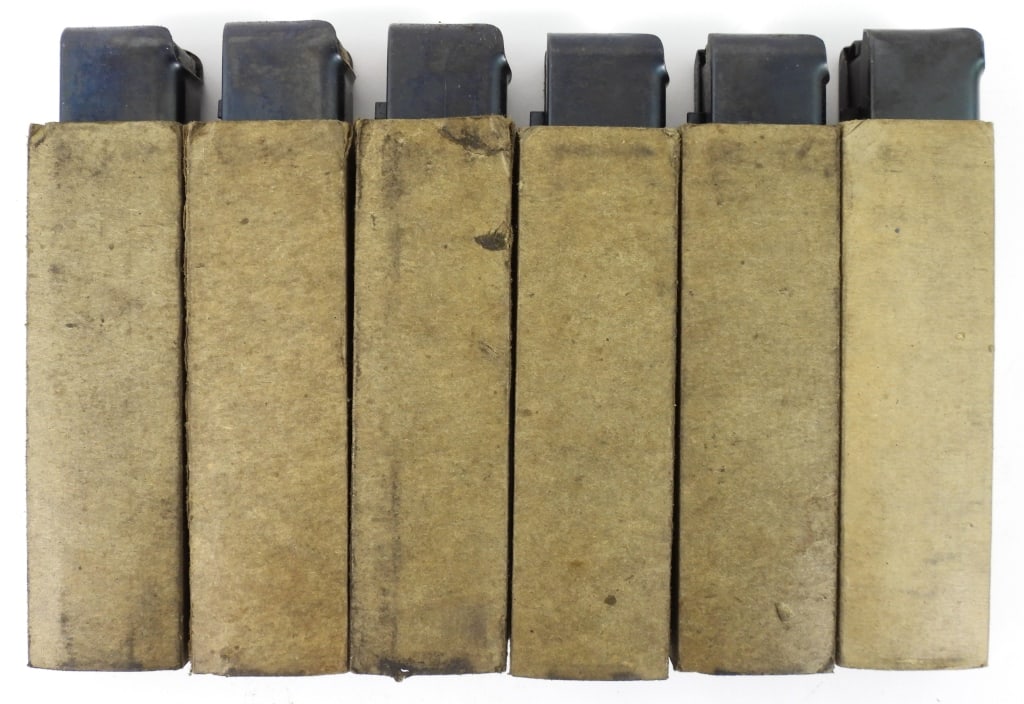 Six Auto Ordnance Thompson SMG Magazines: Six 20 round Thompson SMG magazines in pasteboard sleeves marked "AUTO ORDNANCE CORP./BRIDGEPORT, CONNECTICUT/REG. IN U.S. PAT. OFF.", five marked with "U" on the back of the magazine near the floor