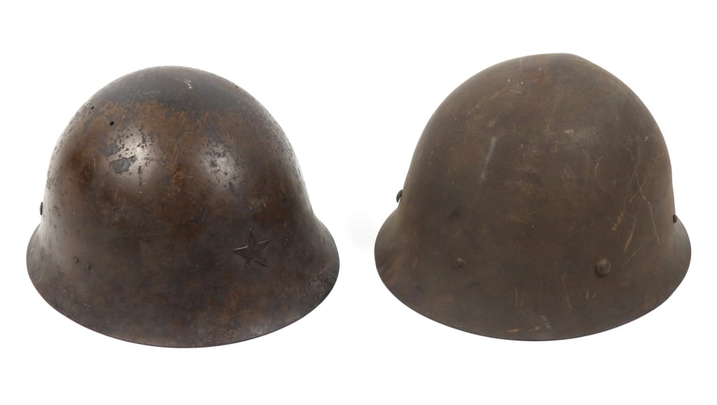 Two WWII Imperial Japanese Helmets: A helmet with remnants of brown paint, a star on the front, a Japanese character painted on the rear inside rim, a leather liner, and a cloth chinstrap; and a civil defense helmet with a cloth