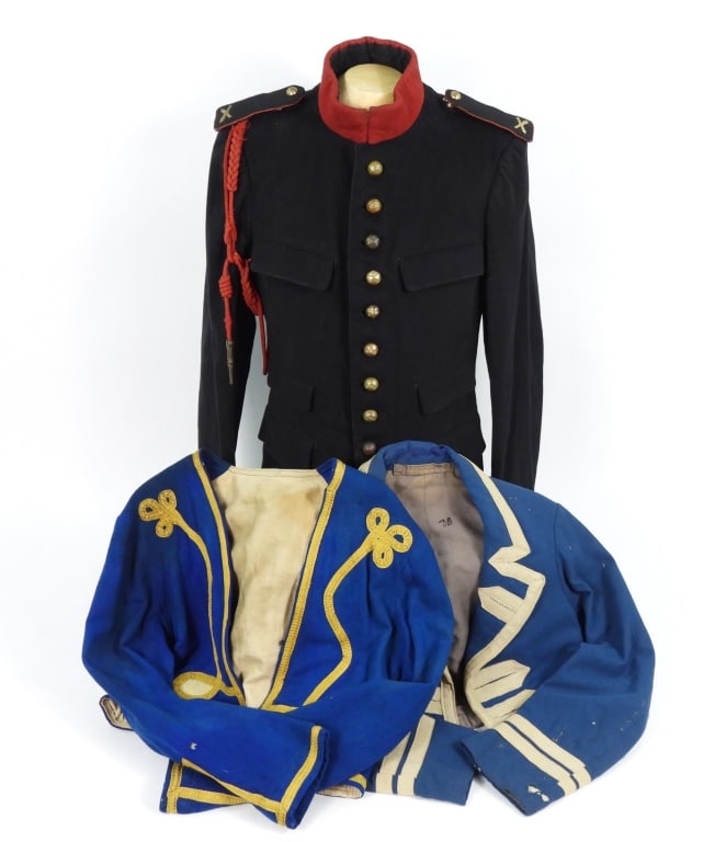 Three French-style Uniform Jackets: A light blue wool jacket with white tape; a royal blue zouave-style jacket with gold/yellow tap; and a French artillery tunic with red collar and red trimmed shoulder boards.