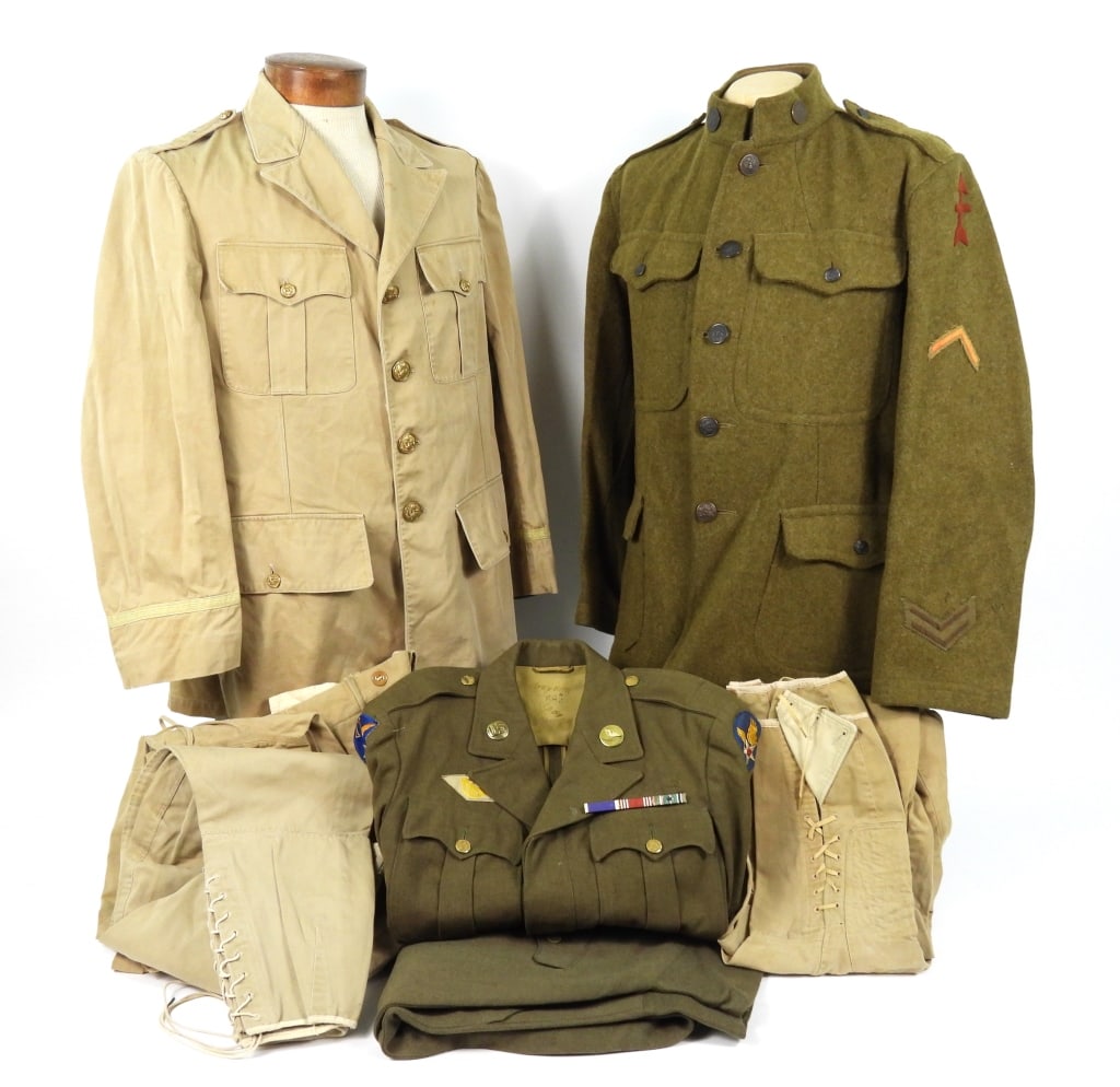 Group of Military Uniforms: A WWII-era khaki cotton twill tunic with brass buttons with three pairs of breeches; an Army Air Corps Ike jacket with a pair of breeches; and a WWI tunic with a 32nd Division patch on the left