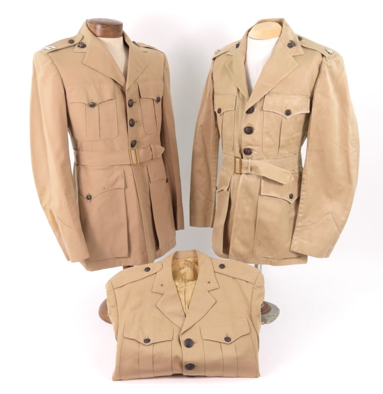 Three US Marine Corps Officer's Summer Tunics: A khaki twill woven summer tunic with brown-painted buttons, marked inside the pocket "GEIGER, G.R."; a khaki twill woven summer tunic with brown-painted buttons, eagle, globe, and anchor insignia, ca