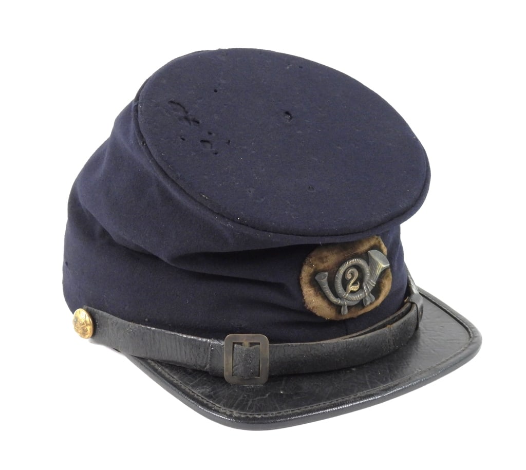 Civil War Officer's Commercial Forage Cap: Dark blue superfine broadcloth cap body, brass bugle insignia with a brass "2" mounted on oval-shaped black velvet and sewn to the front of the cap body, eagle "I" brass chinstrap buttons, Japanned